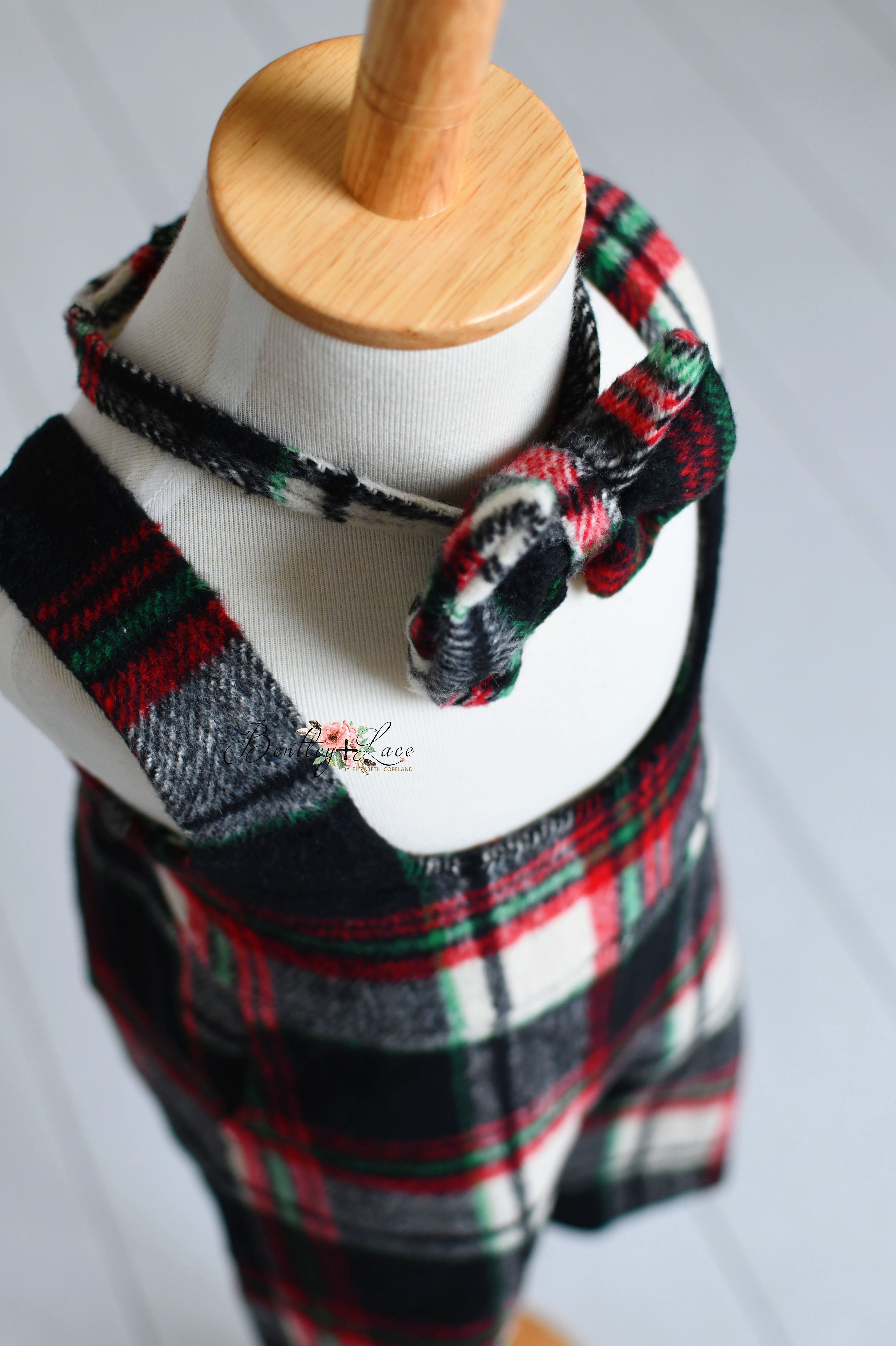 Two children's outfits in classic plaid pattern, featuring bow ties, styled on mannequins.