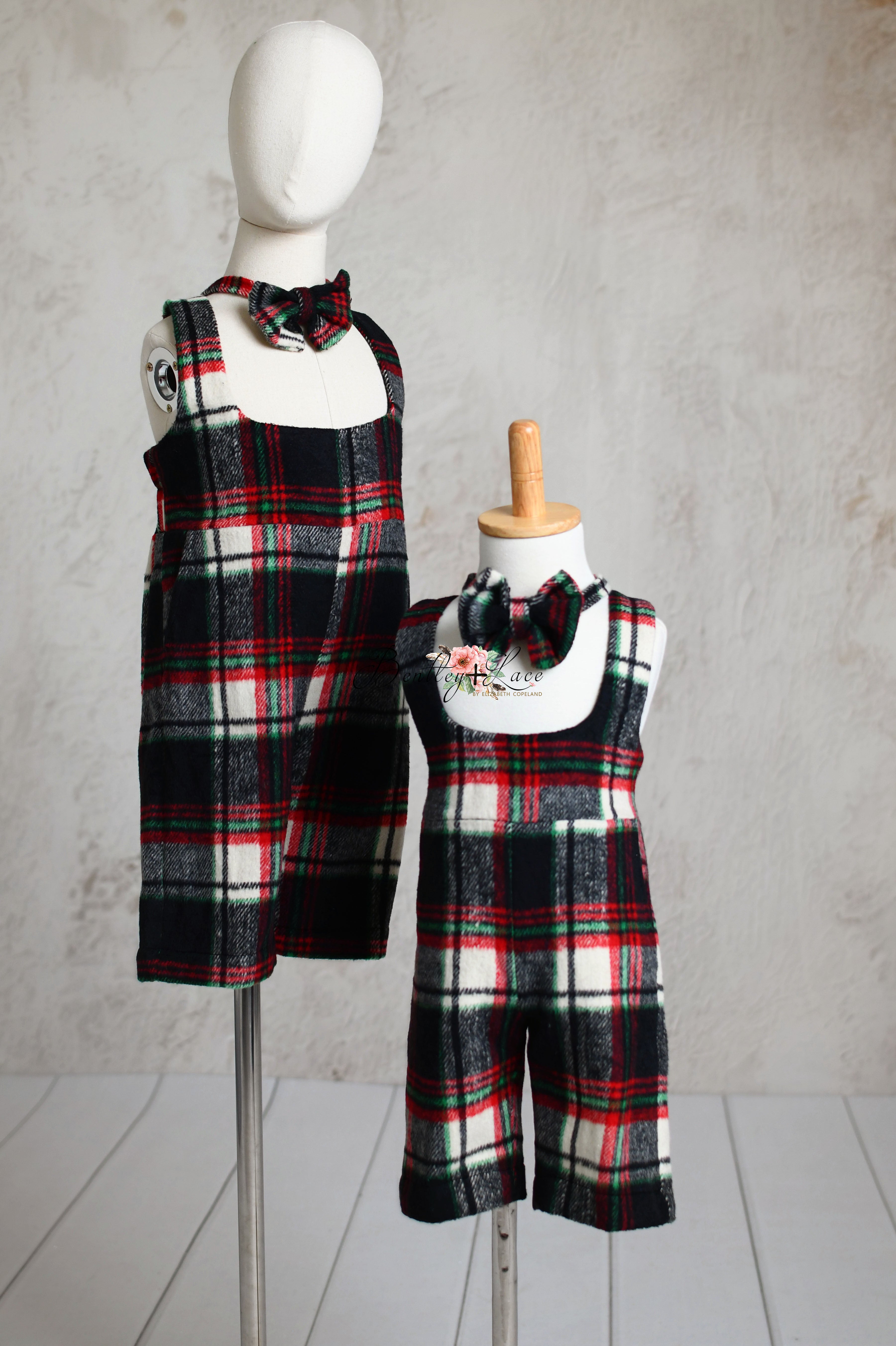 Matching children's plaid outfits in red, black, and white, displayed on mannequins with bow ties.