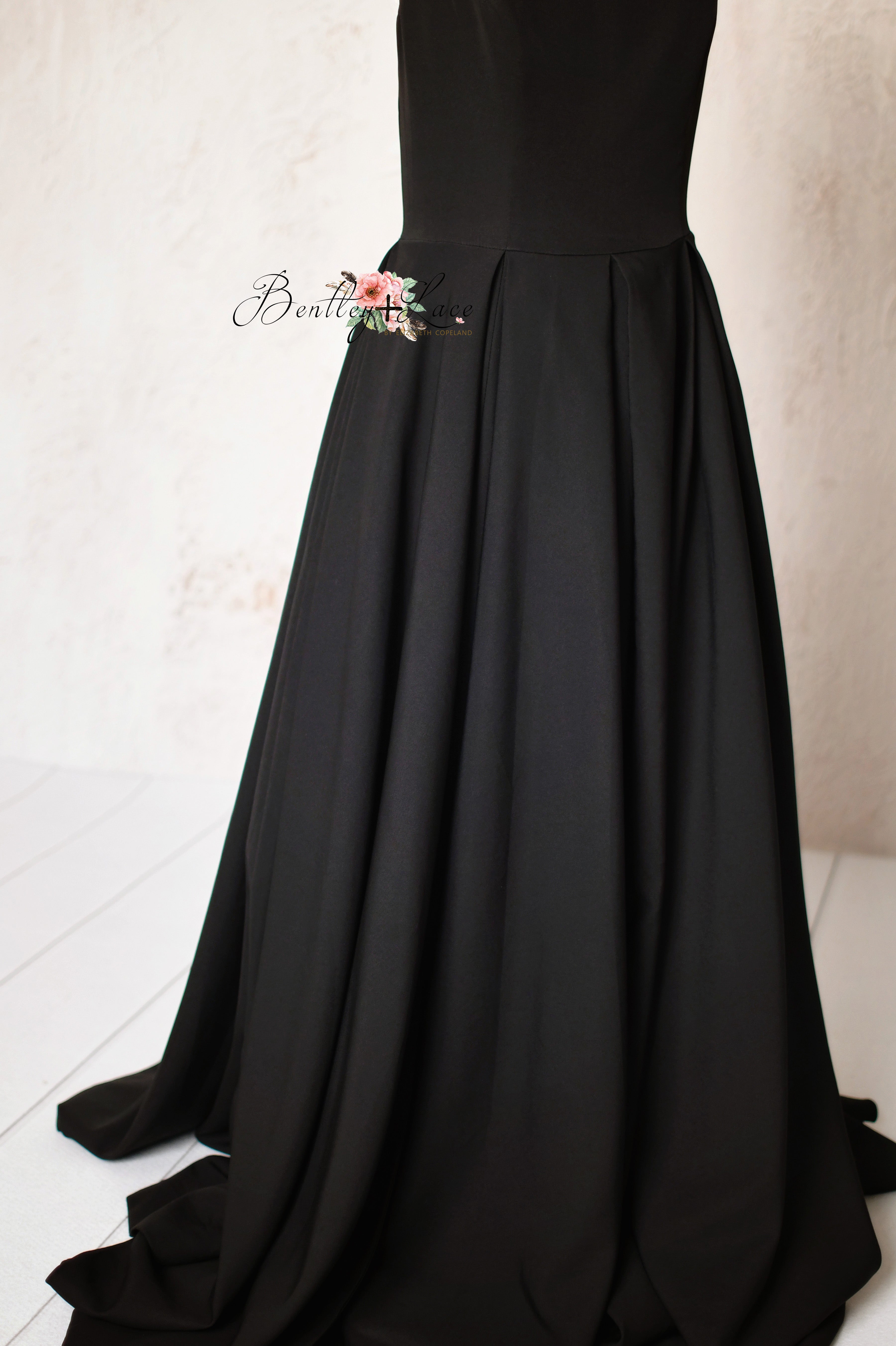 Alchemy black couture gown with floor-length flowing skirt, perfect for formal events.