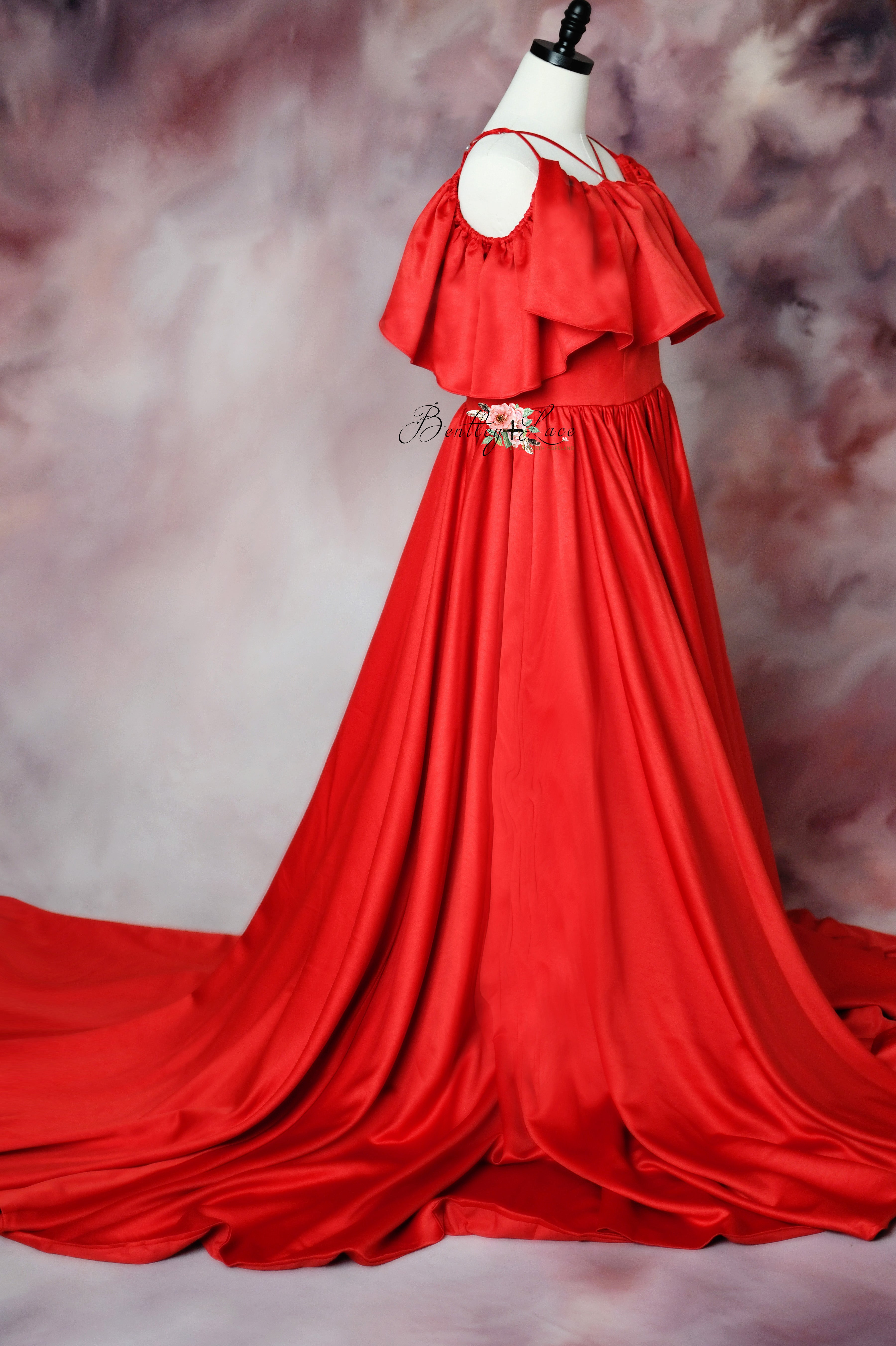 Mannequin wearing a red formal gown with intricate ruffle detailing, ideal for styled sessions