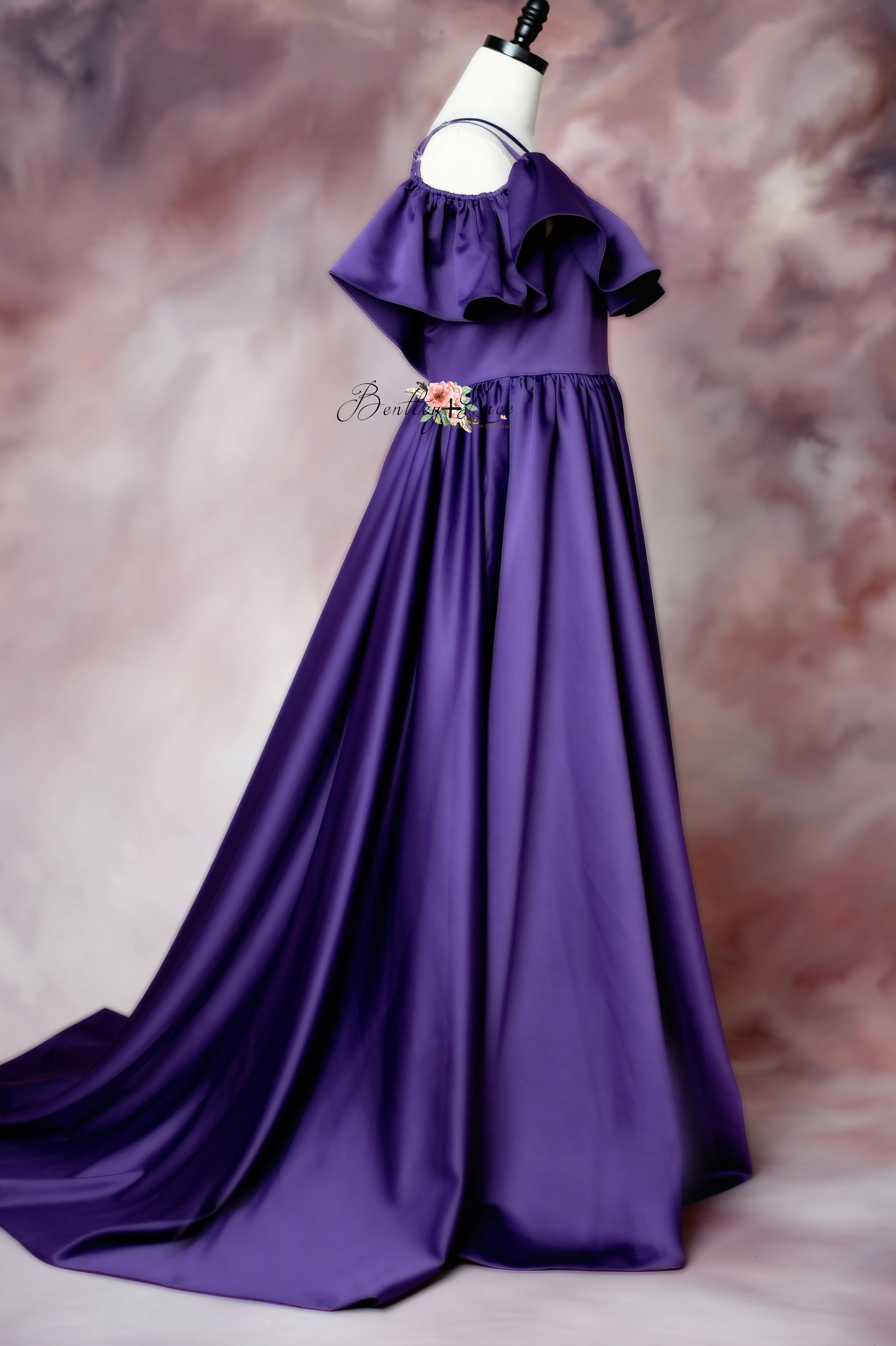 Chic off-shoulder purple gown with a layered bodice and an opulent satin train.