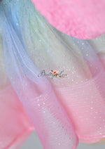 A vibrant and glittering pink sequin dress with a flared skirt, showcased on a wooden stand with a minimalist backdrop.
