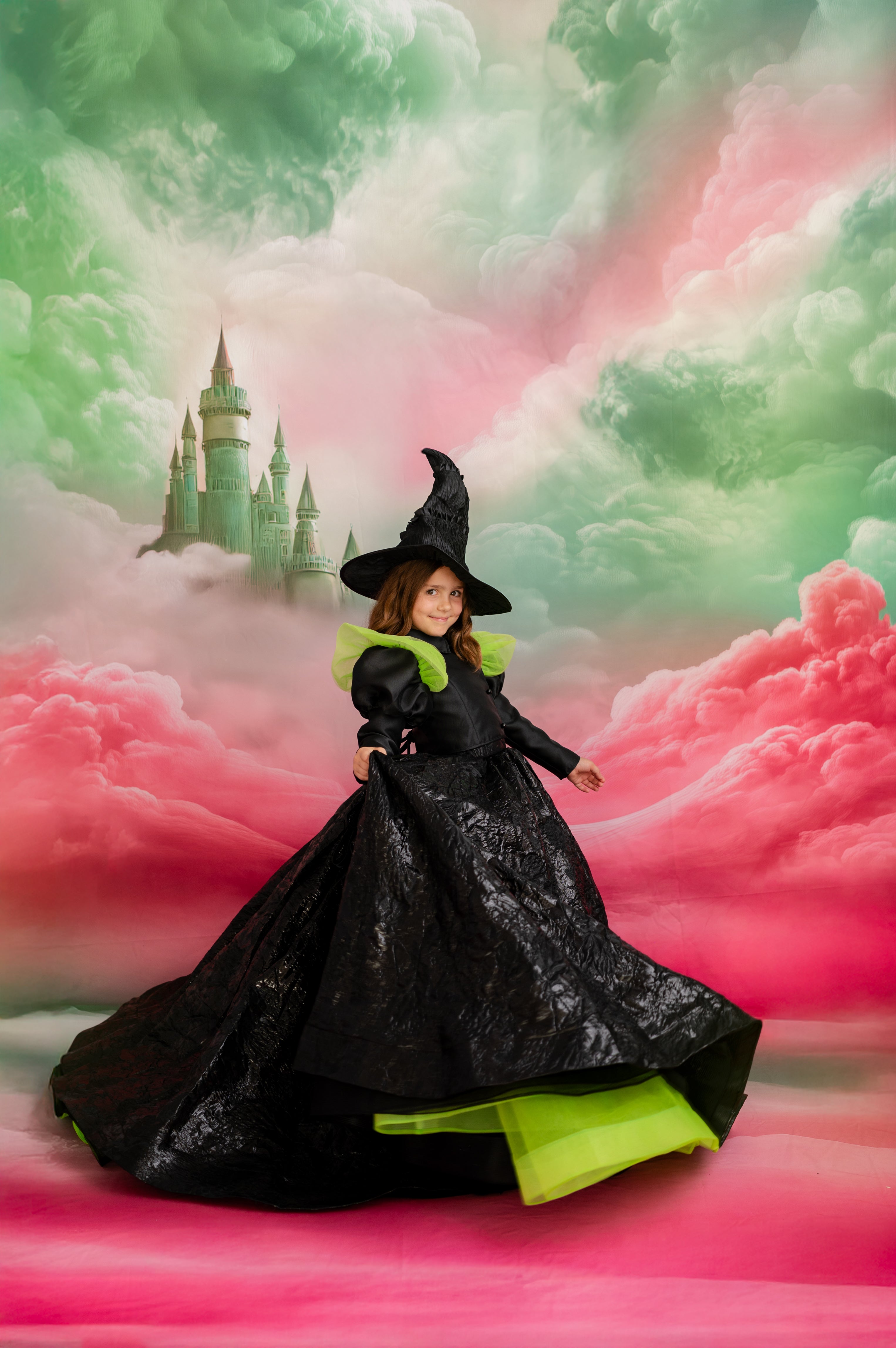 Child in a witch costume standing in front of a fantasy castle with pink and green clouds.