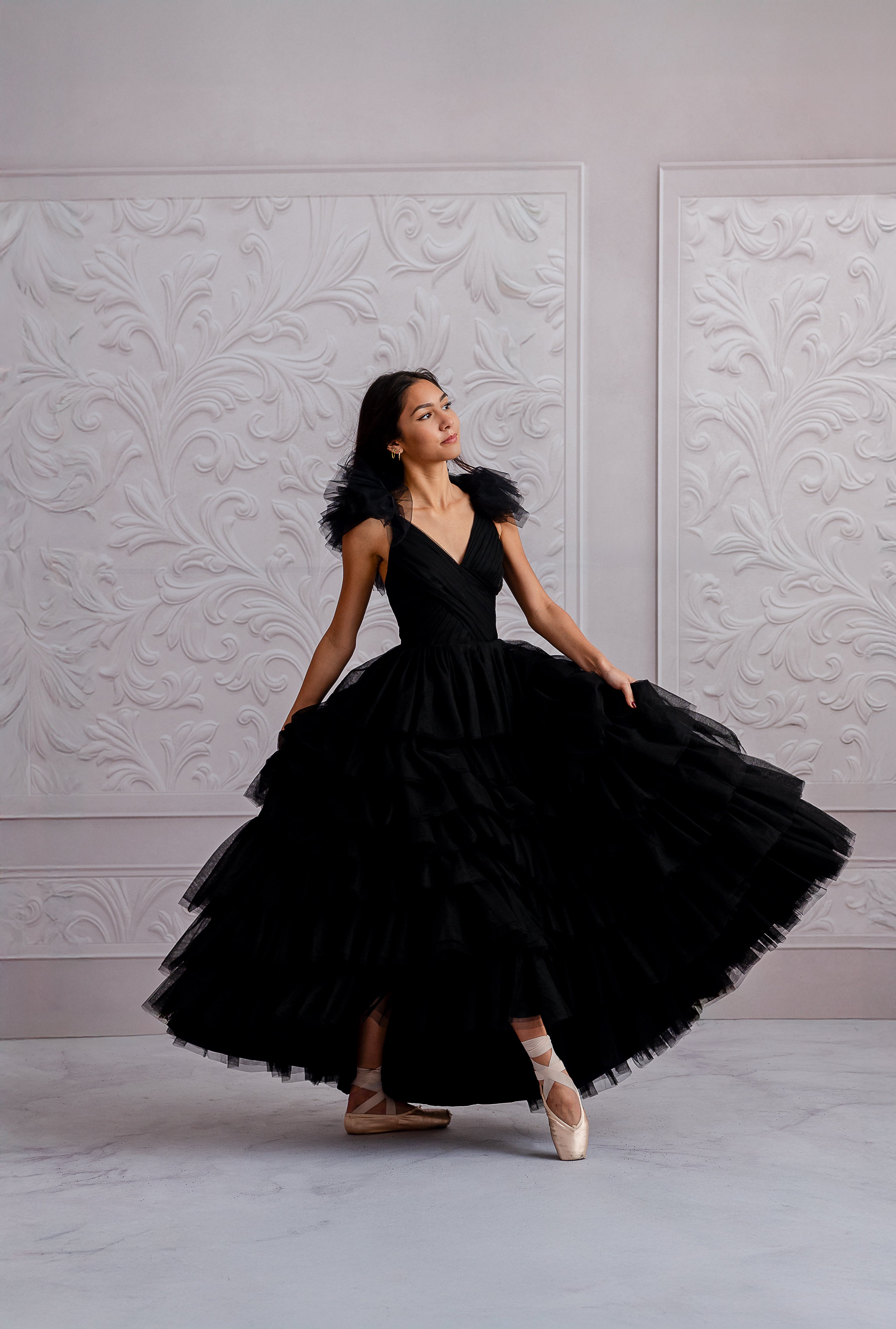 Elegant black tulle gown styled with ballet shoes in a photoshoot setting.
