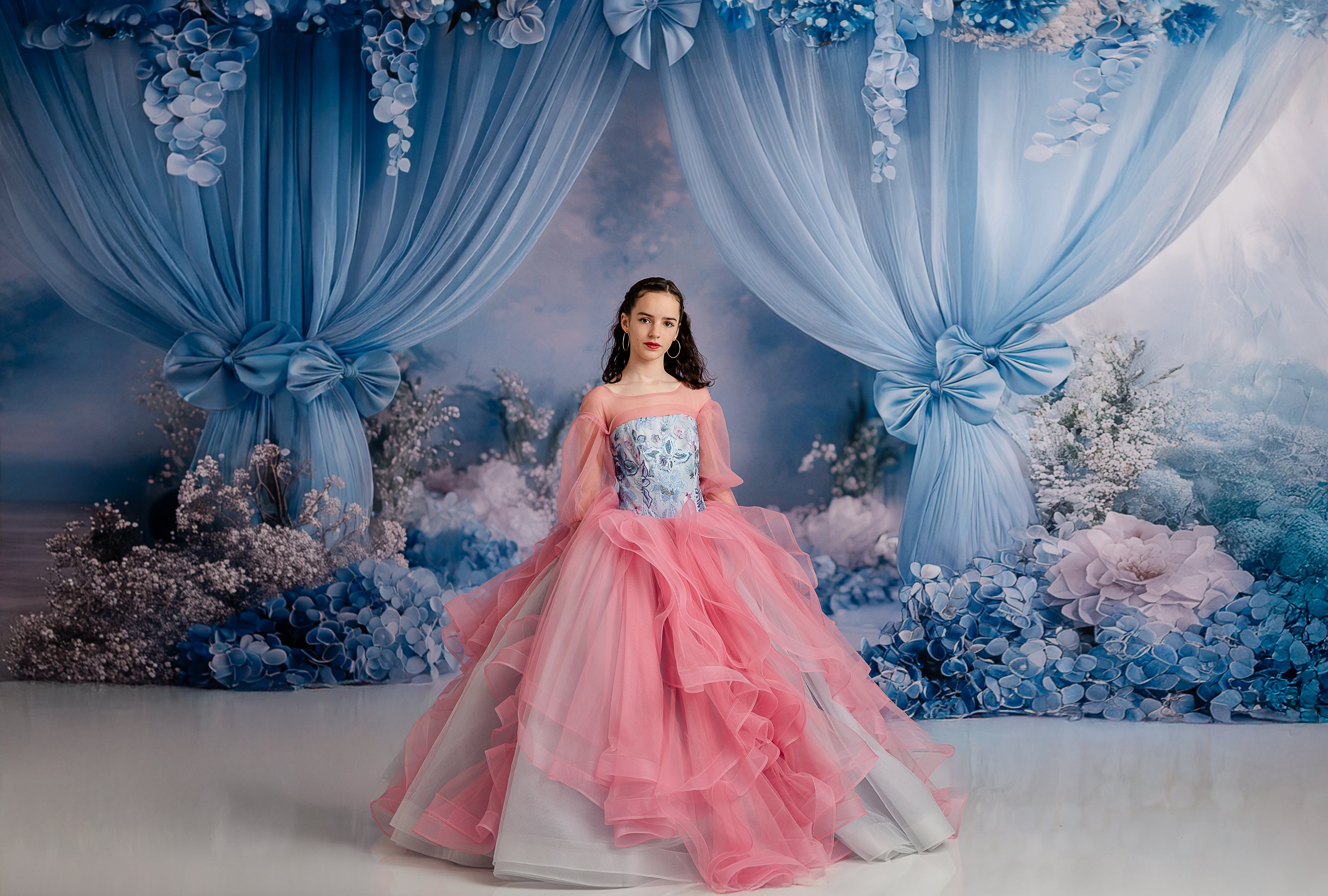 Full-length shot of the "Blush & Blossoms" gown in action during a photography session, capturing the ethereal movement of the cascading tulle.