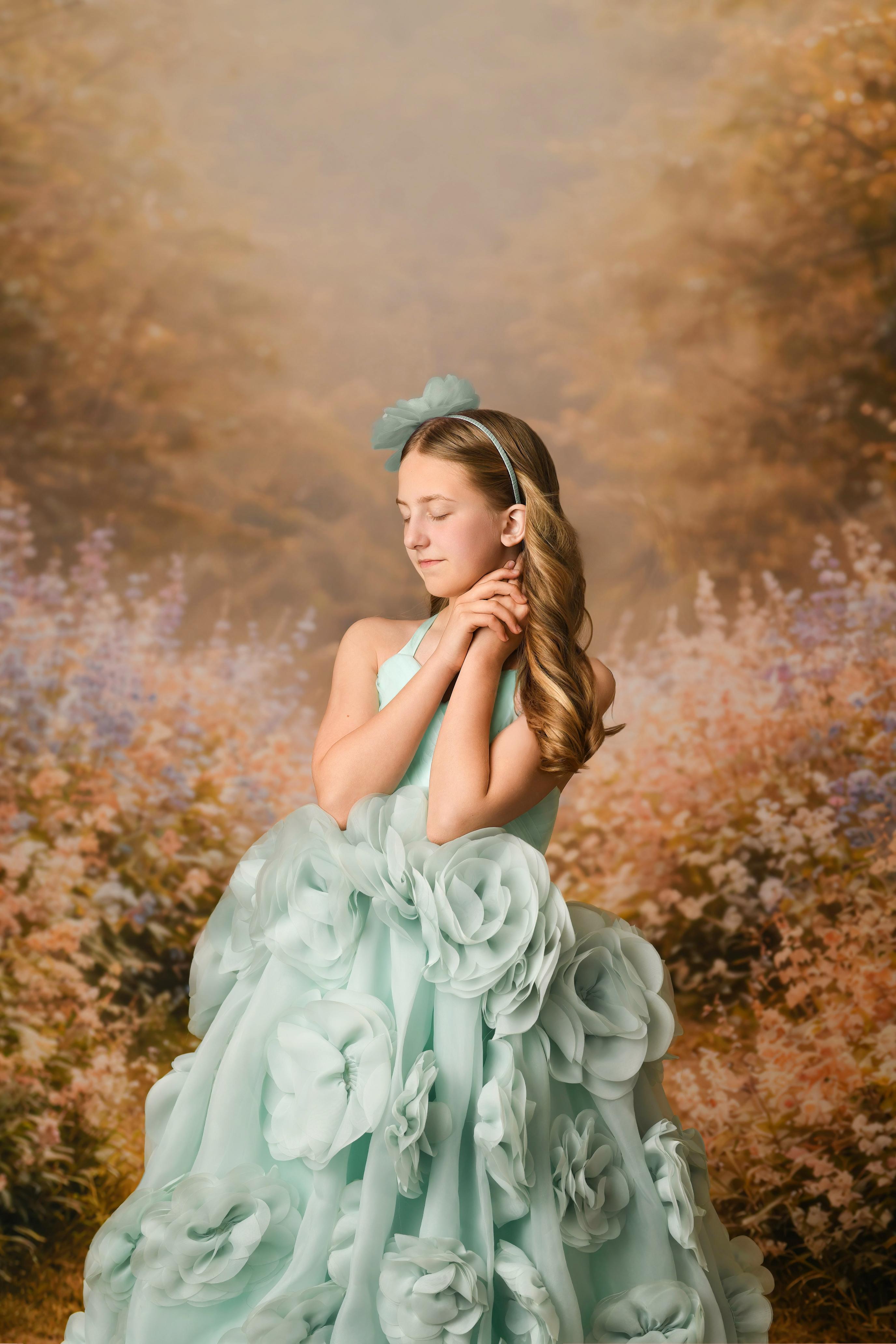 Young girl in a light blue floral dress against a blurred natural background