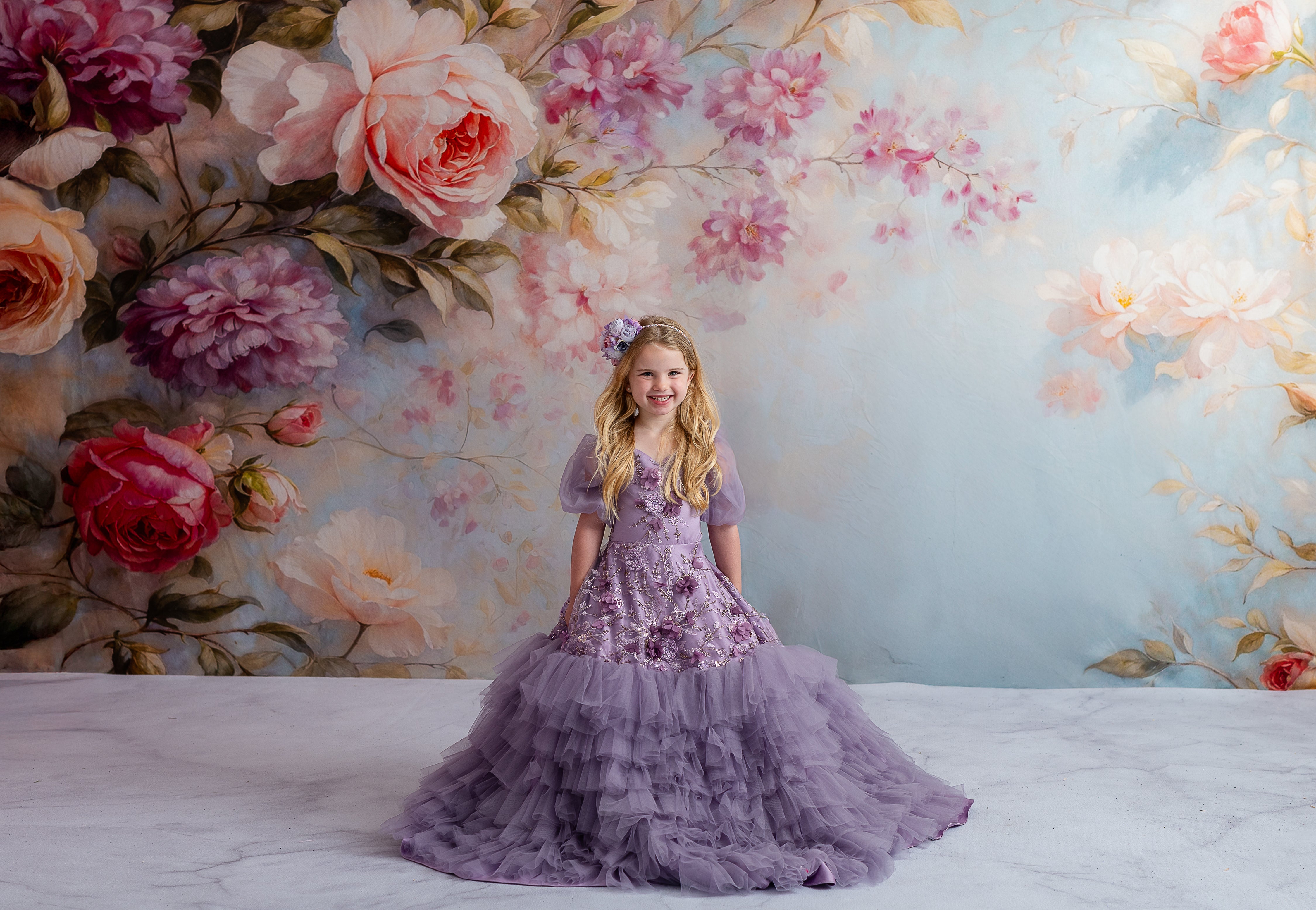 Close-up of floral appliqués on lavender child’s gown with soft detachable sleeves.

