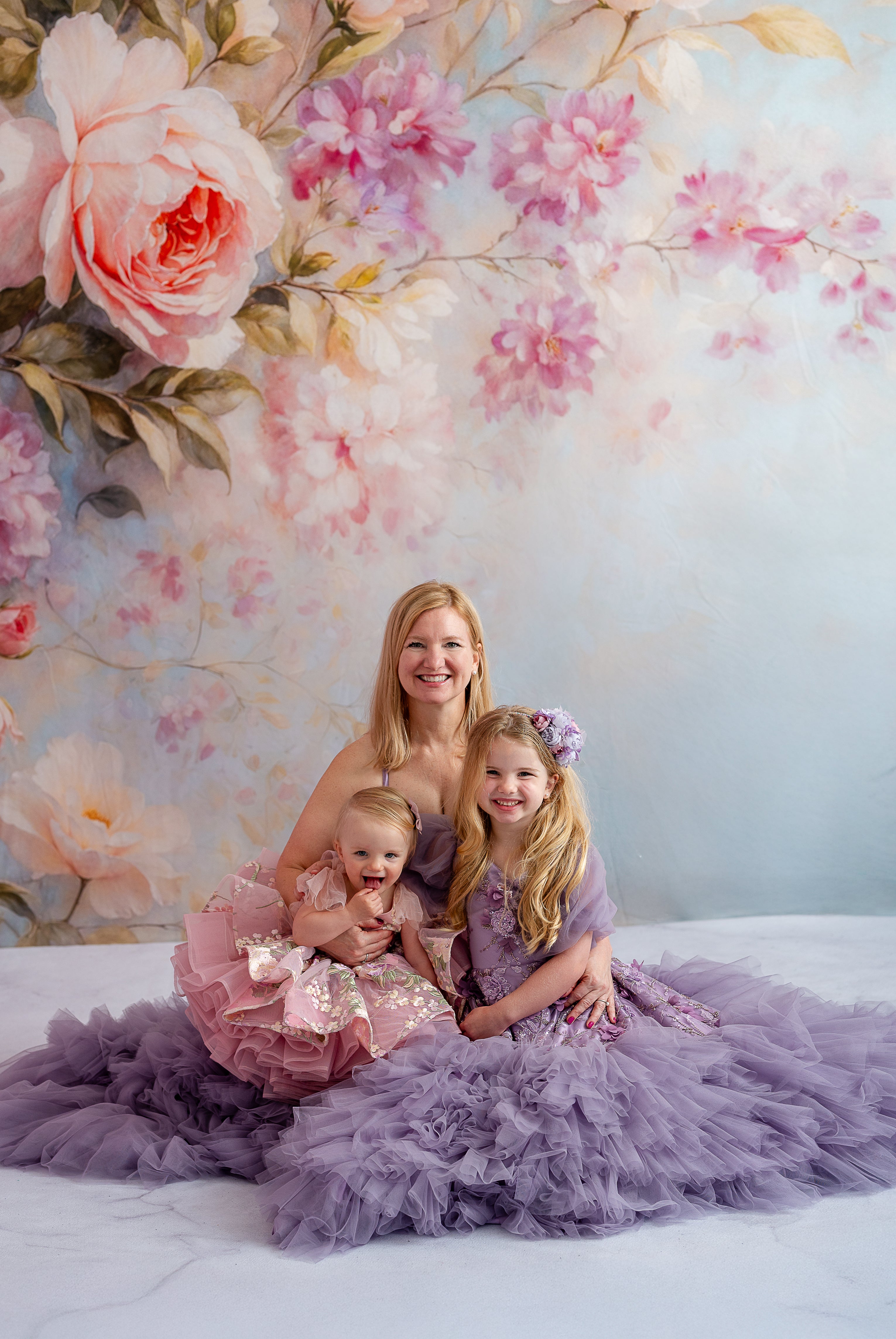 Mom and daughter in matching lavender gowns with floral appliqués during golden hour photoshoot.

