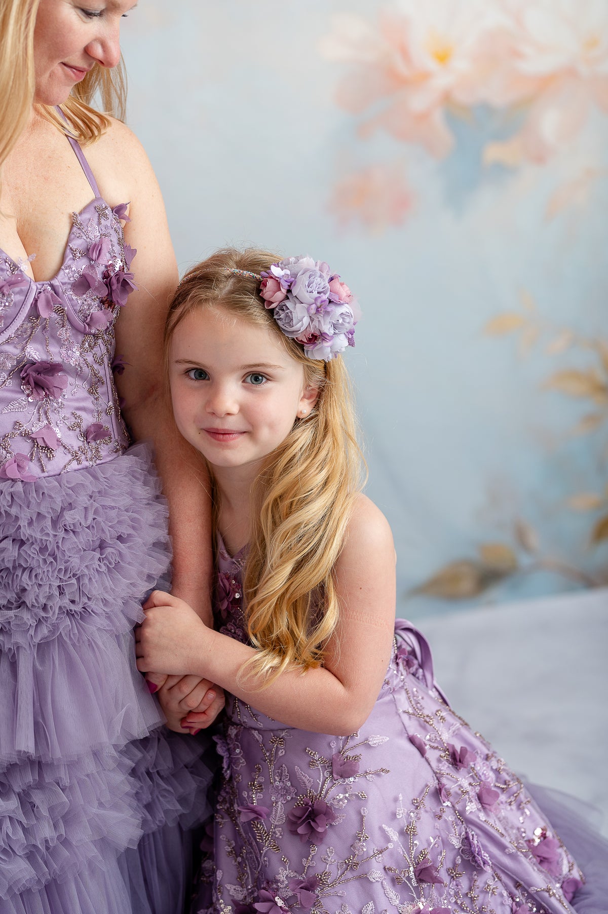 Bentley and Lace mommy and me session featuring coordinating floral lavender gowns under soft sunlight.

