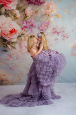 Mother twirling with daughter in matching lavender tulle gowns with floral accents.

