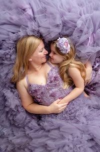 Mommy and me portrait in coordinating Violet Grace lavender tulle gowns surrounded by flowers.

