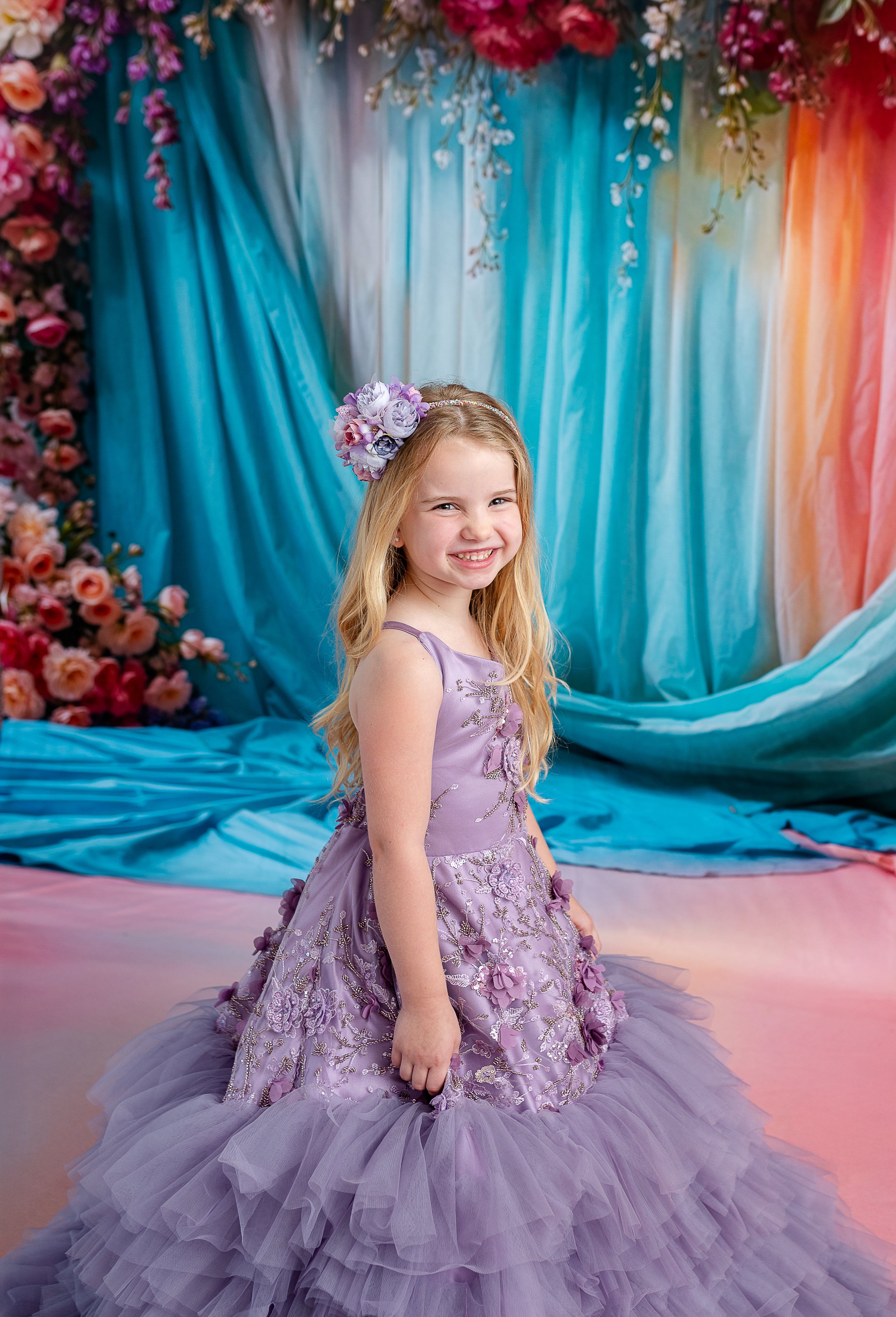 Portrait of child in romantic lavender dress with detachable puff sleeves and floral embellishments.

