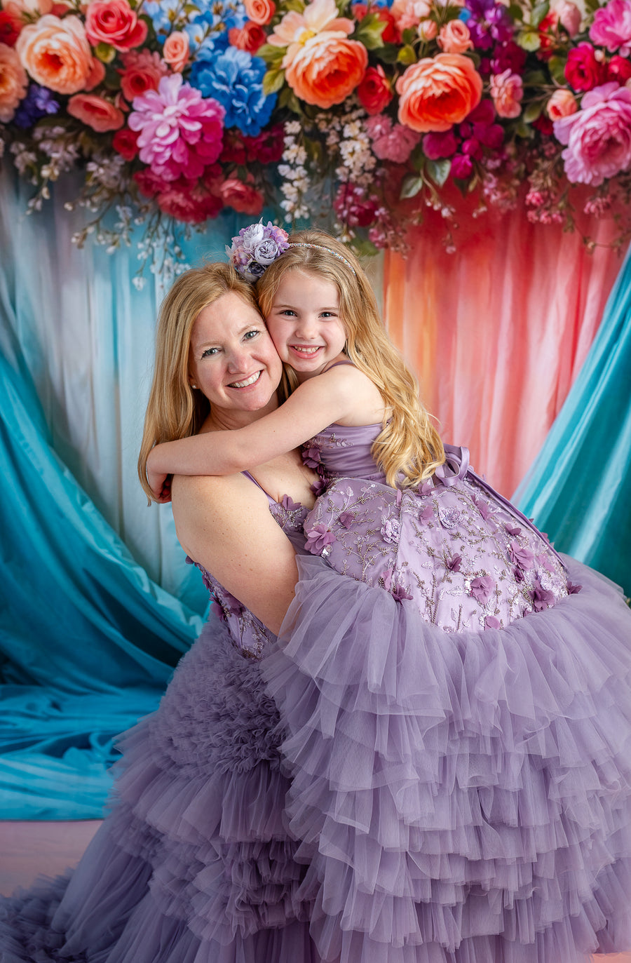 Side-by-side photo of mom and daughter in floor-length Violet Grace gowns with lavender tones.

