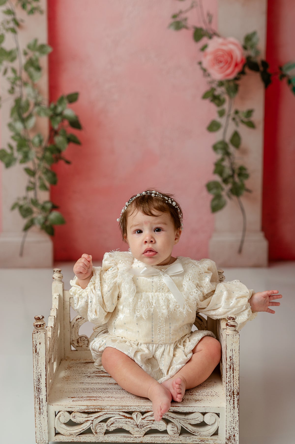 Baby wearing The Rosalie Romper in soft cream velvet with embroidered lace, bishop sleeves, and scalloped collar, styled for an heirloom photography session.

