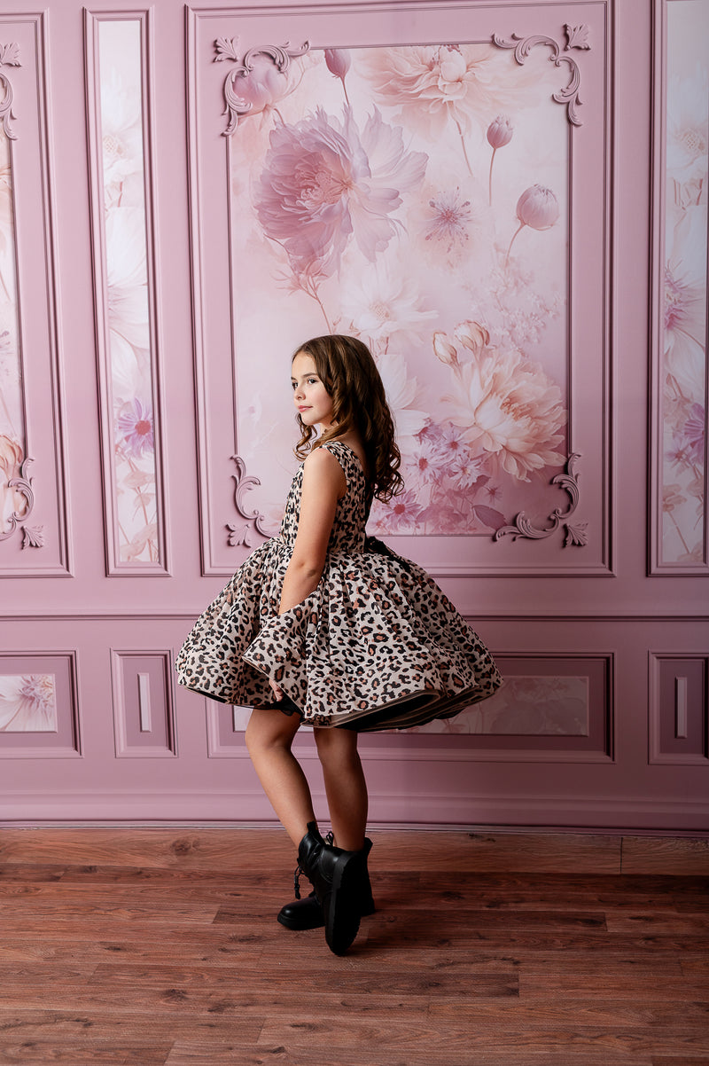 "Celebrate birthdays in style with this adorable leopard print dress, captured in a creative photography setup."
