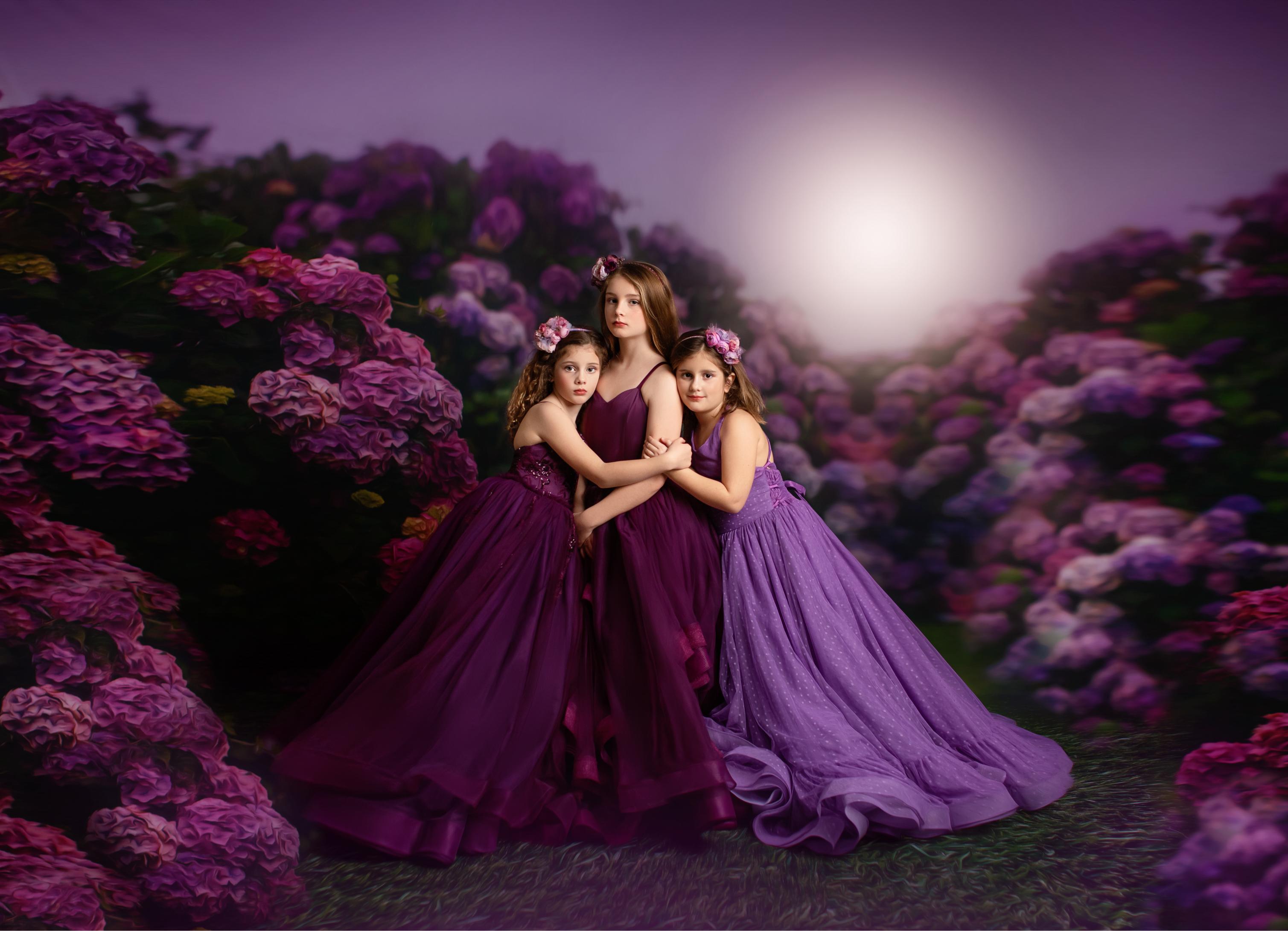 Three women in purple dresses standing in a field of purple flowers with a bright light in the background.