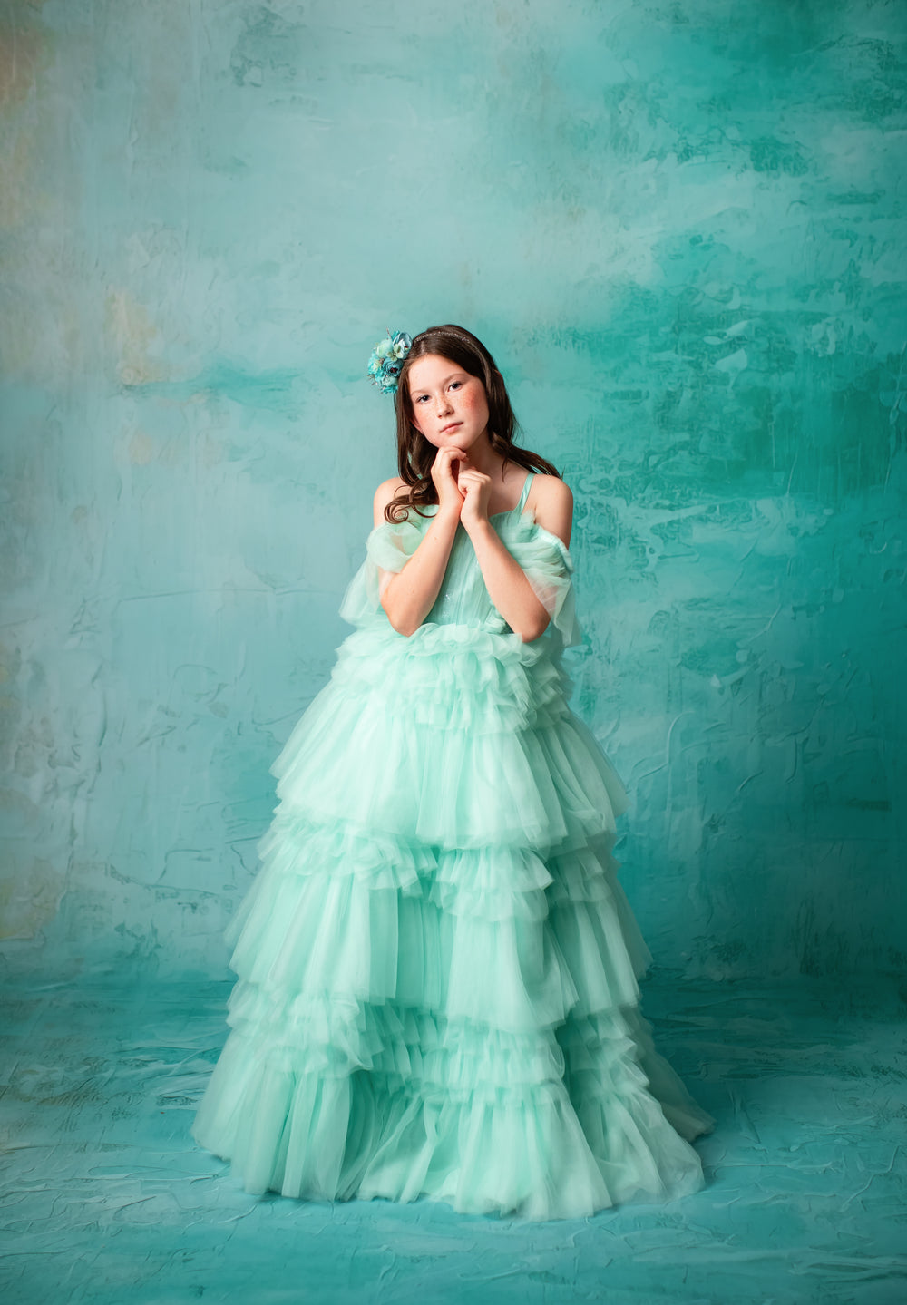 "Whimsical mint green dress with layered tulle skirting worn by a young girl."
