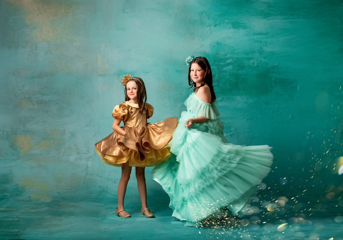 "Elegant mint green tulle gown with layers of ruffles worn by a young girl."

