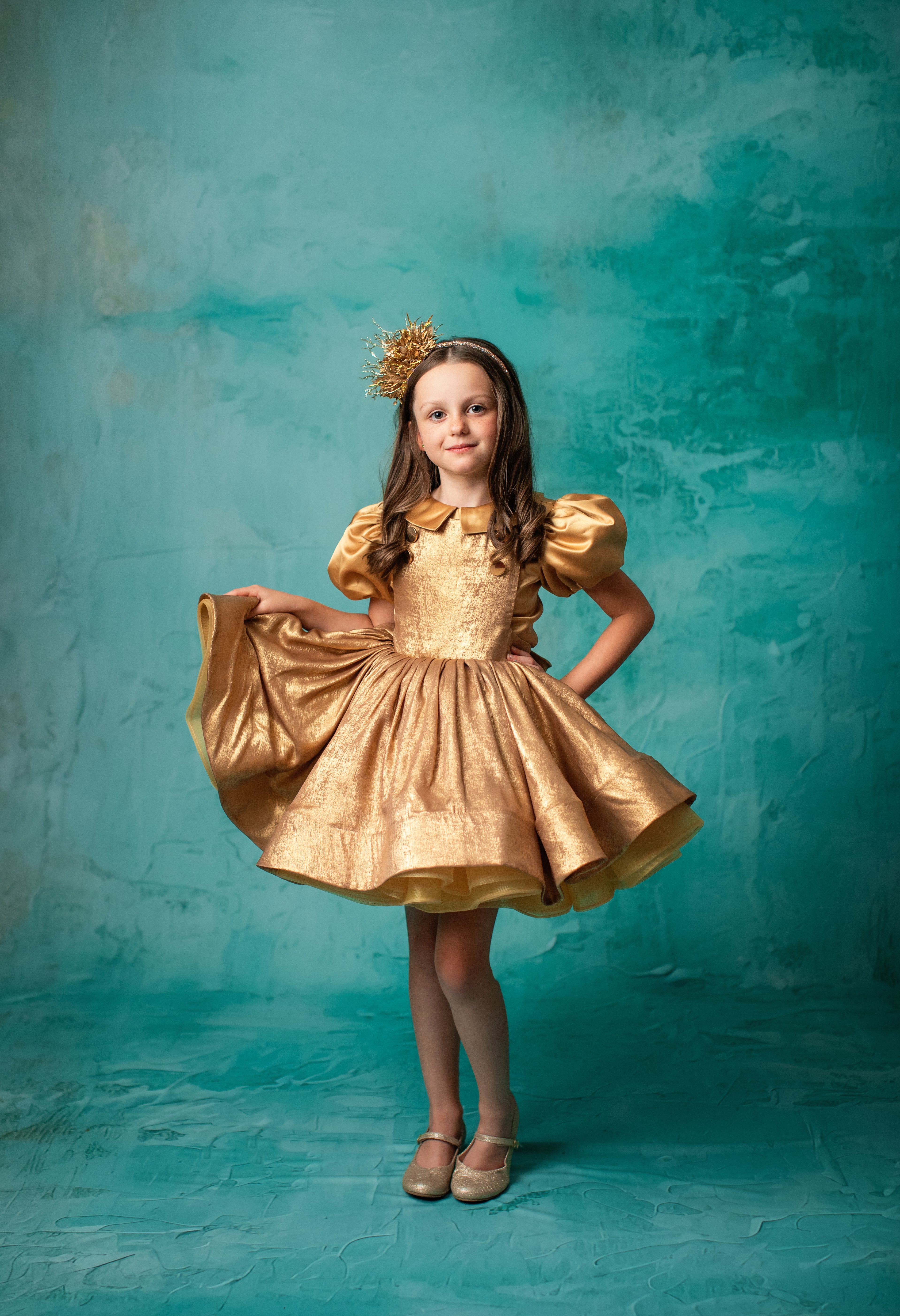 "Elegant mint green tulle gown with layers of ruffles worn by a young girl."
