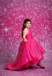 Young girl in a bright pink dress against a pink starry background