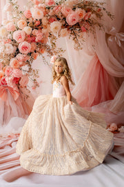 "Girl wearing Garden of Dreams floor-length couture dress in blush and champagne lace"