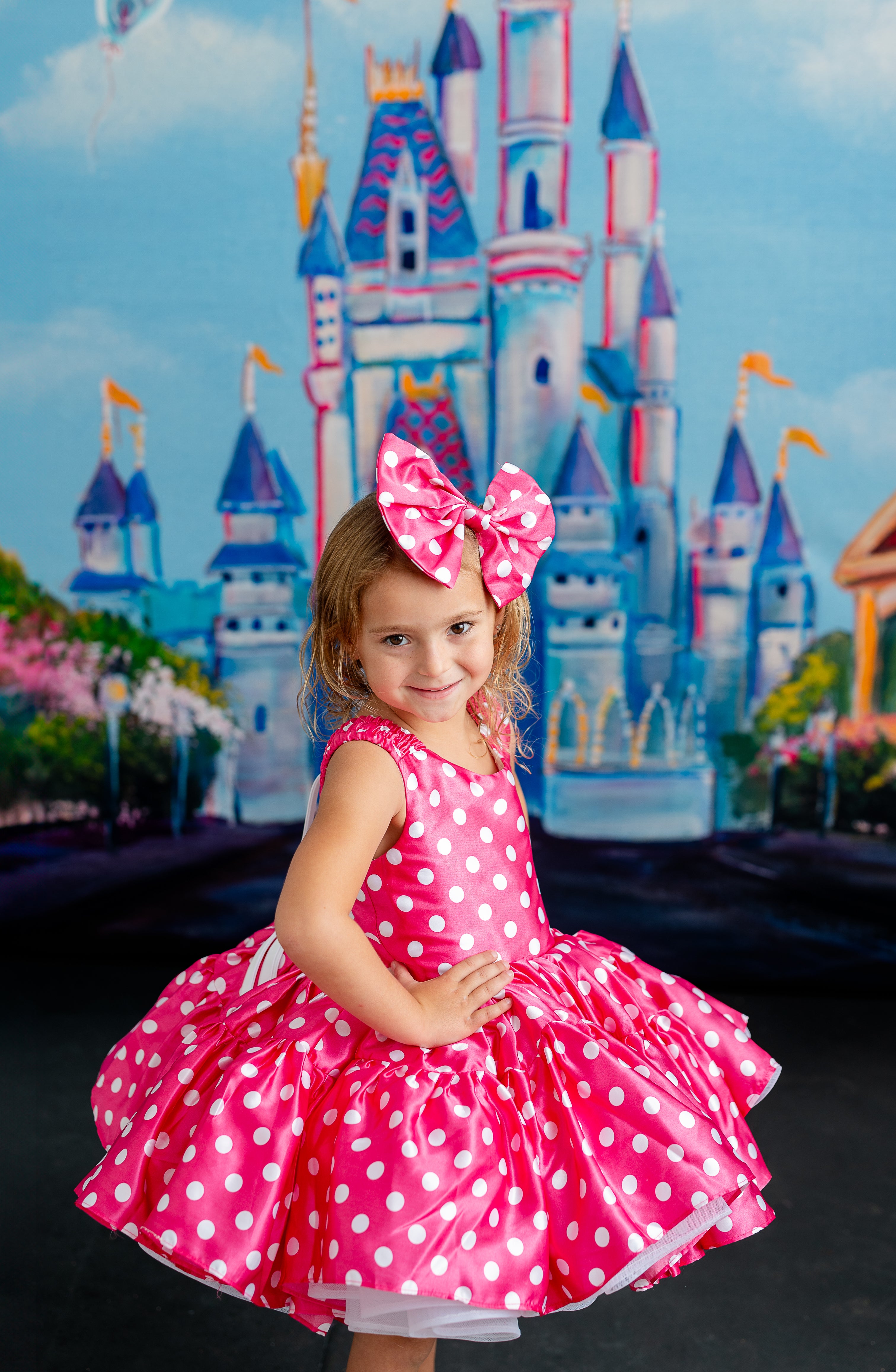 "Playful Minnie Mouse-inspired dress in pink with white polka dots, featuring a large bow detail and puffed sleeves for a whimsical touch."
