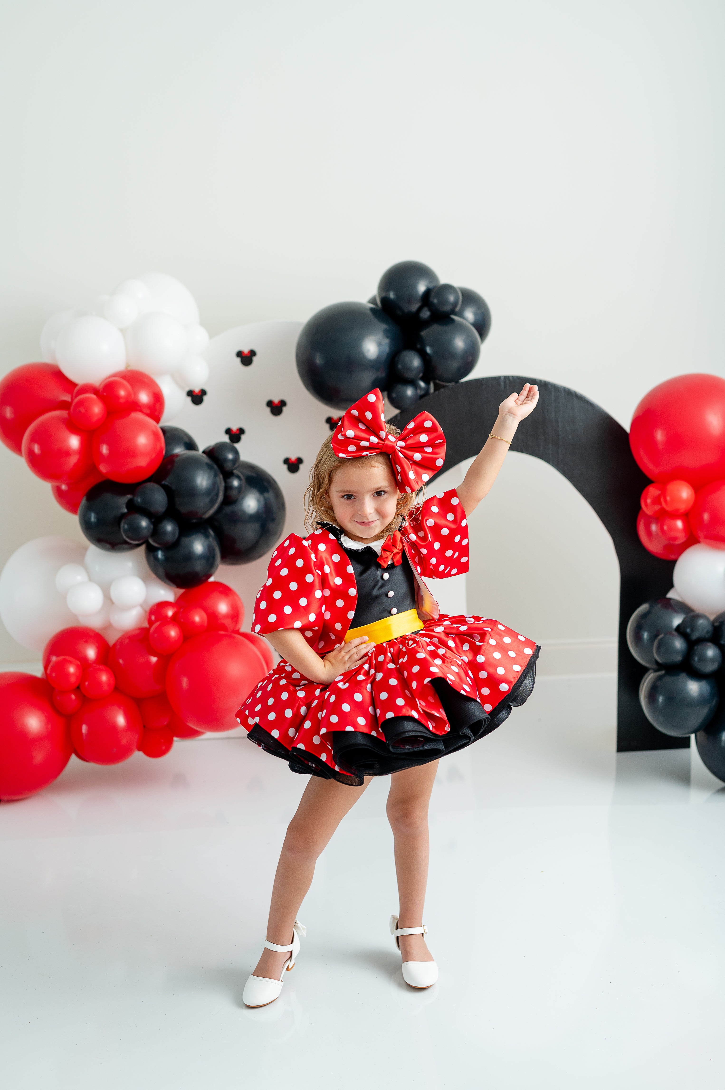 "Fun Minnie Mouse-inspired dress in vibrant red, embellished with white polka dots and black trim, perfect for themed parties and photoshoots."





