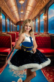 Young girl in a decorated train car with red seats and ornate ceiling.