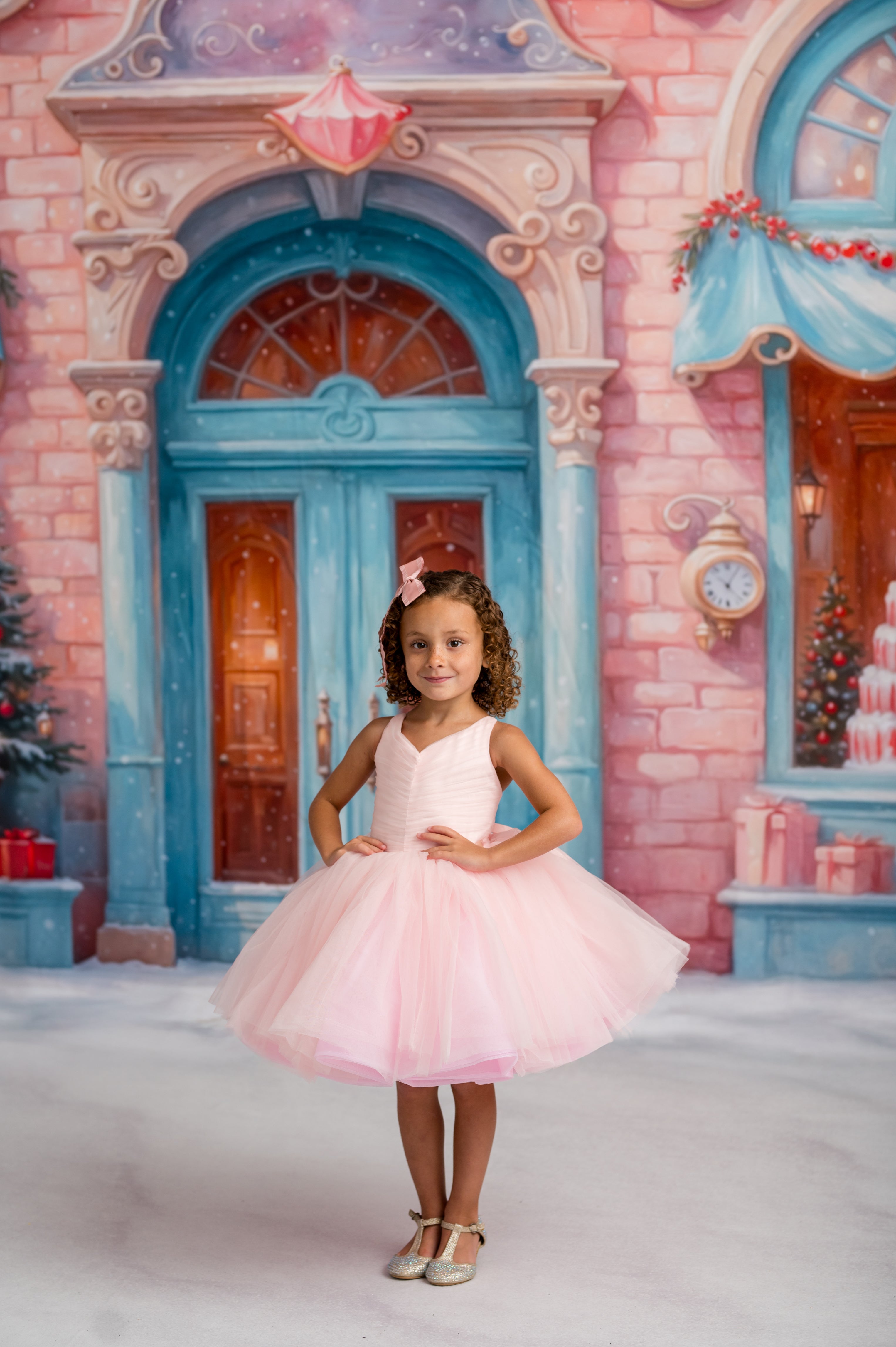 Young girl in a pink dress standing in front of a fairy-tale castle backdrop