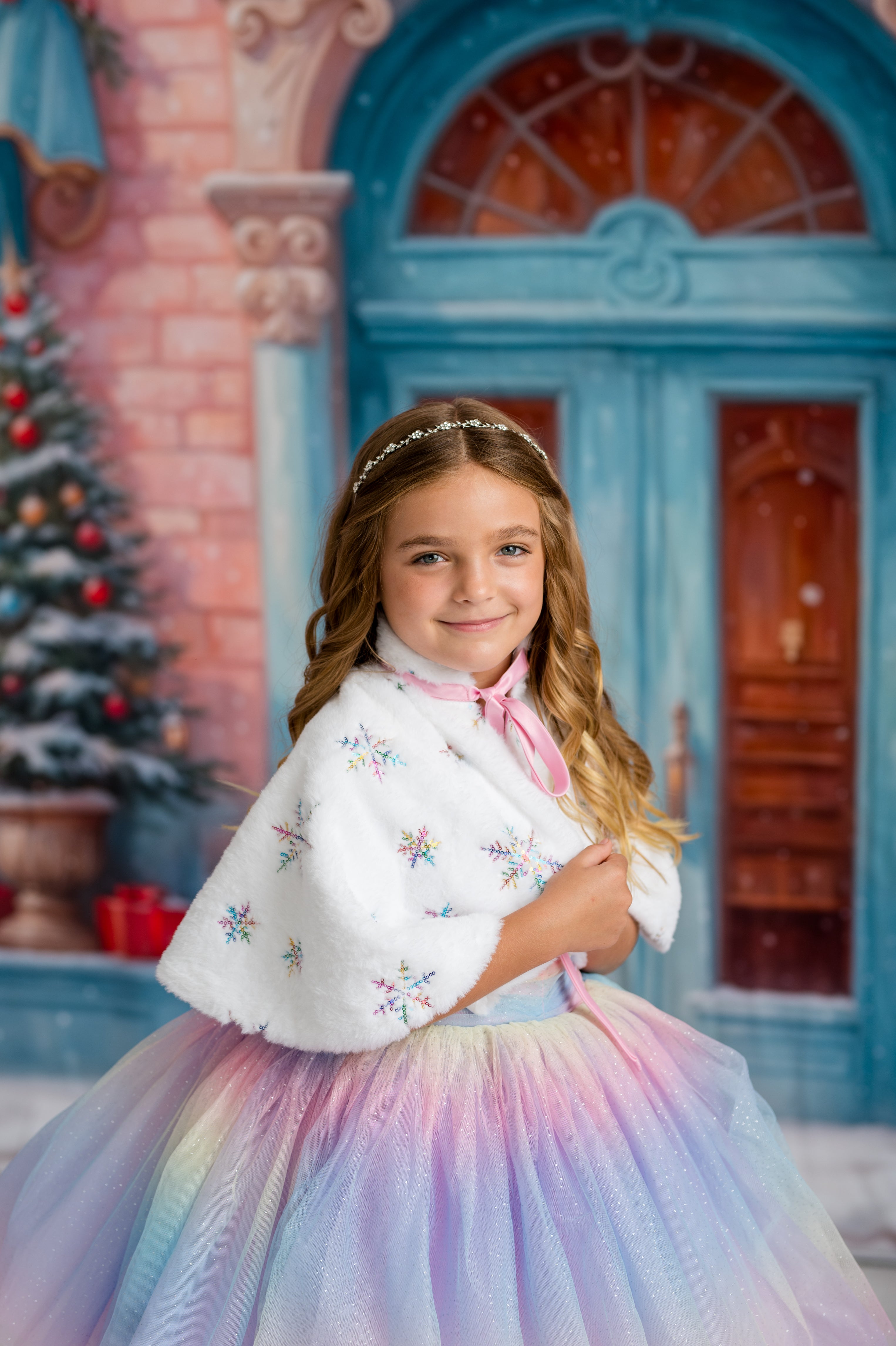 Young girl in a colorful dress with a white shawl against a festive background