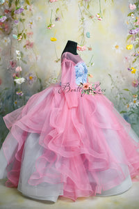 Luxury pink and blue couture gown with sheer puff sleeves and layered tulle skirt.
