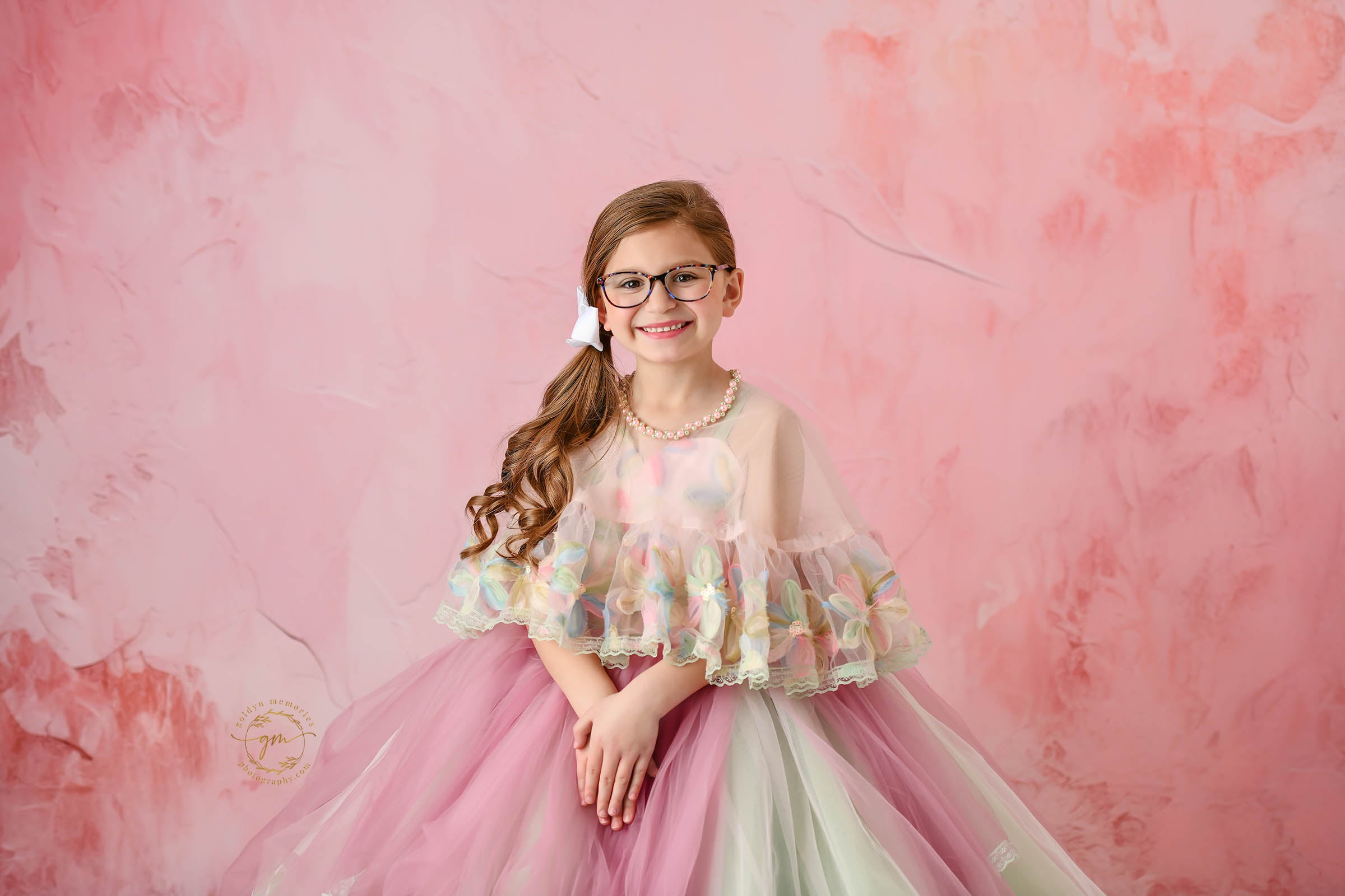 Graceful young girl wearing a stunning floral dress with delicate, detailed embroidery.
