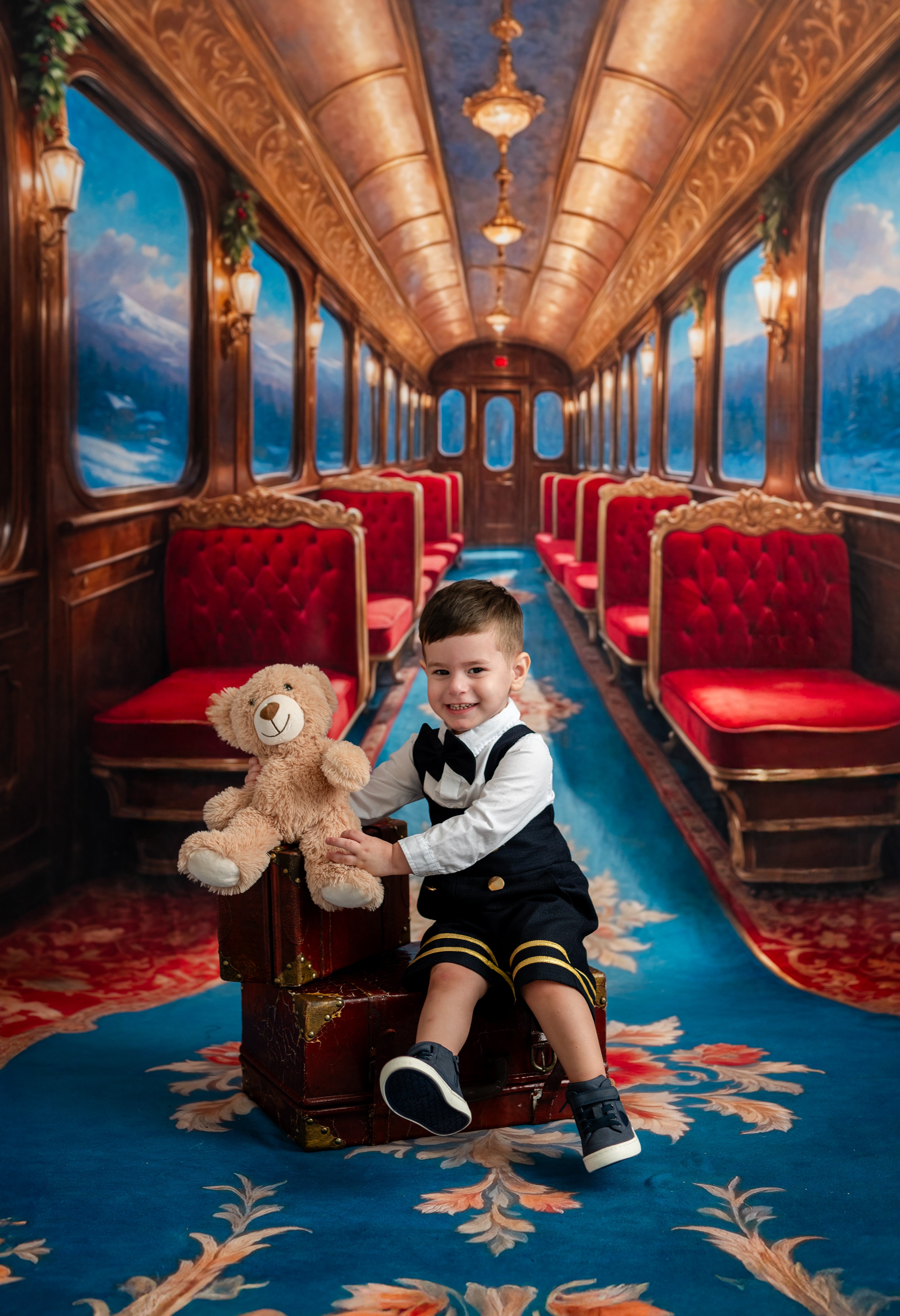 Child in formal attire sitting on a plush train seat with a teddy bear, surrounded by red seats and ornate decor.