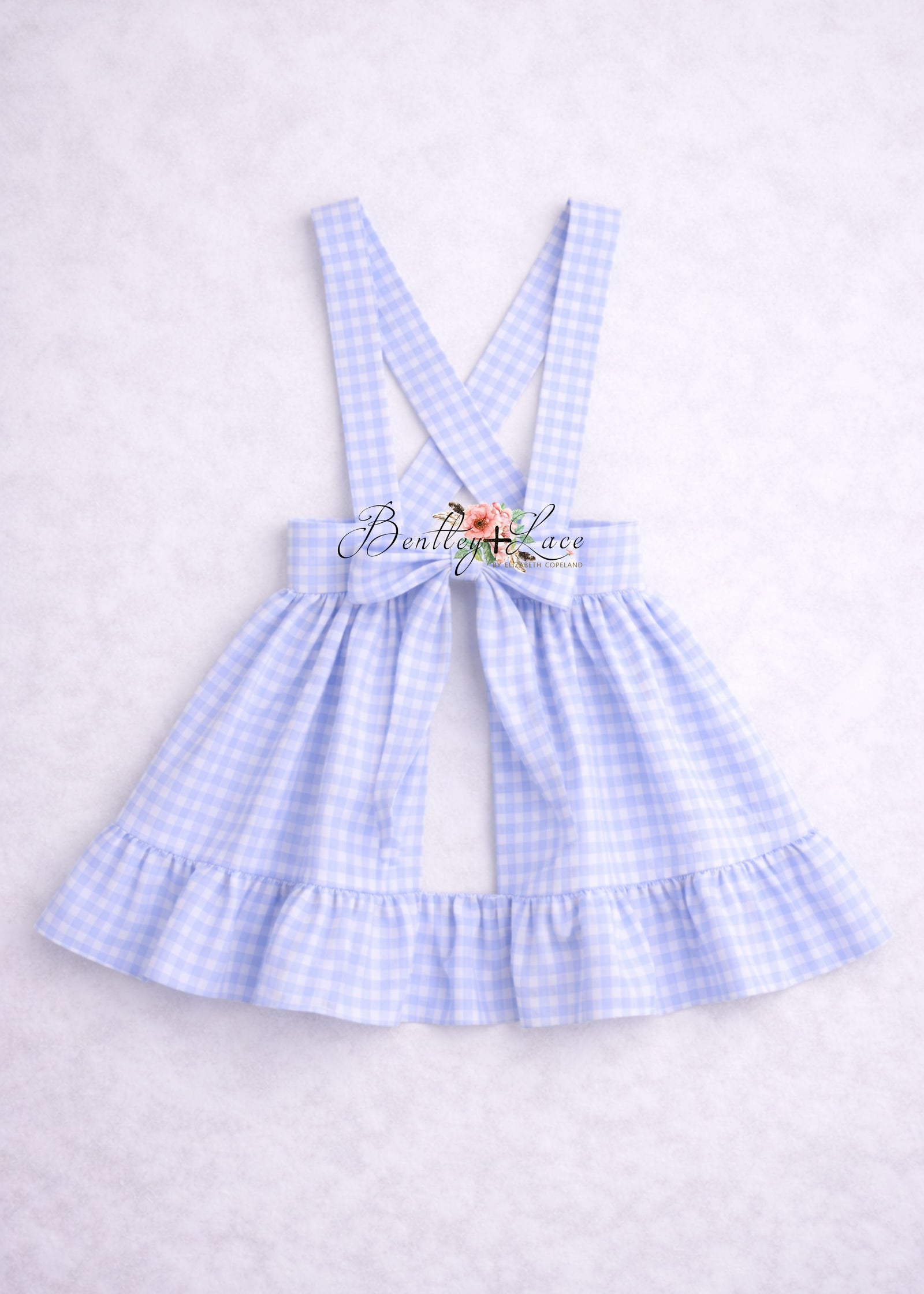 Light blue checkered dress with suspenders on a white background