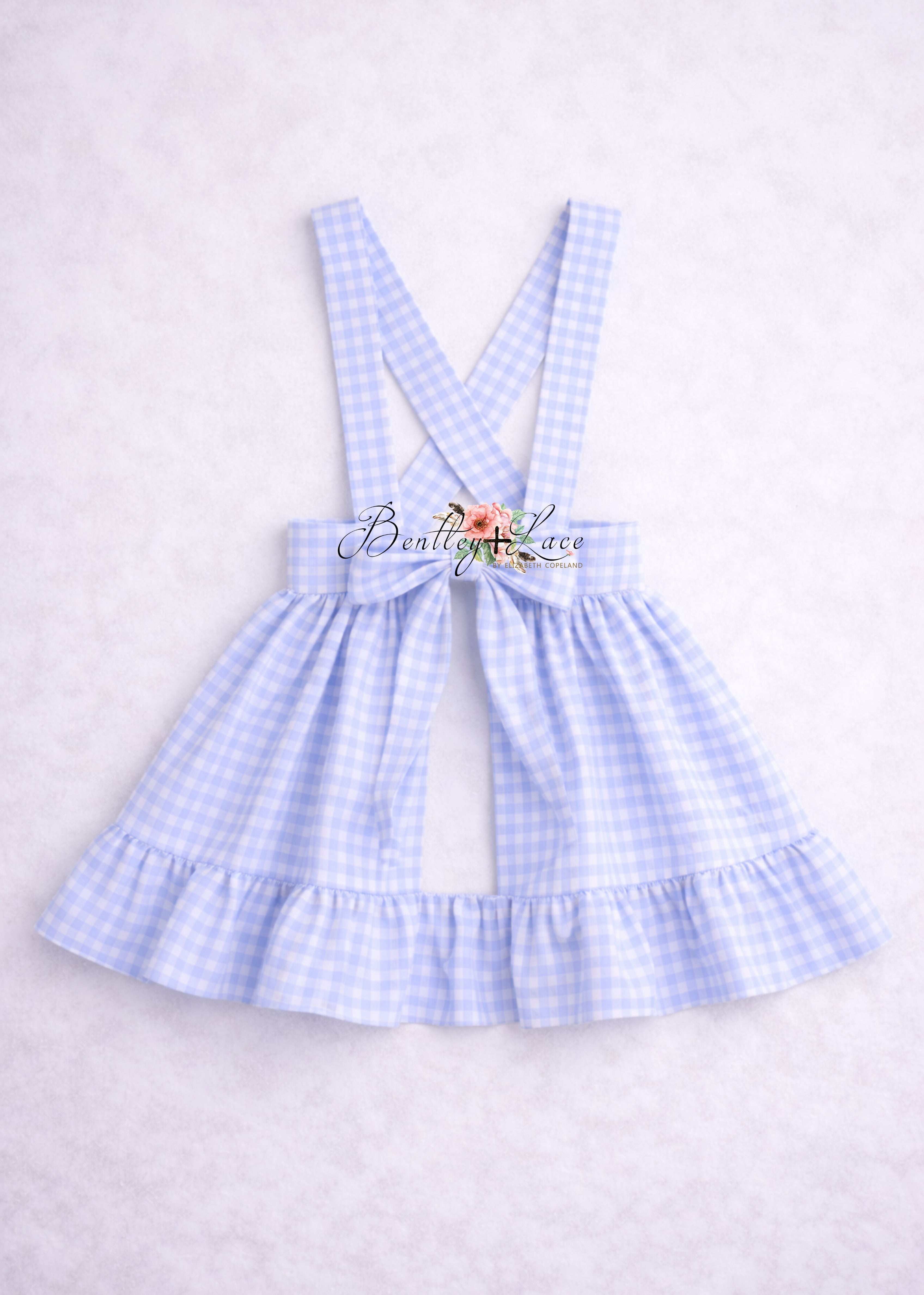 Light blue checkered dress with suspenders on a white background