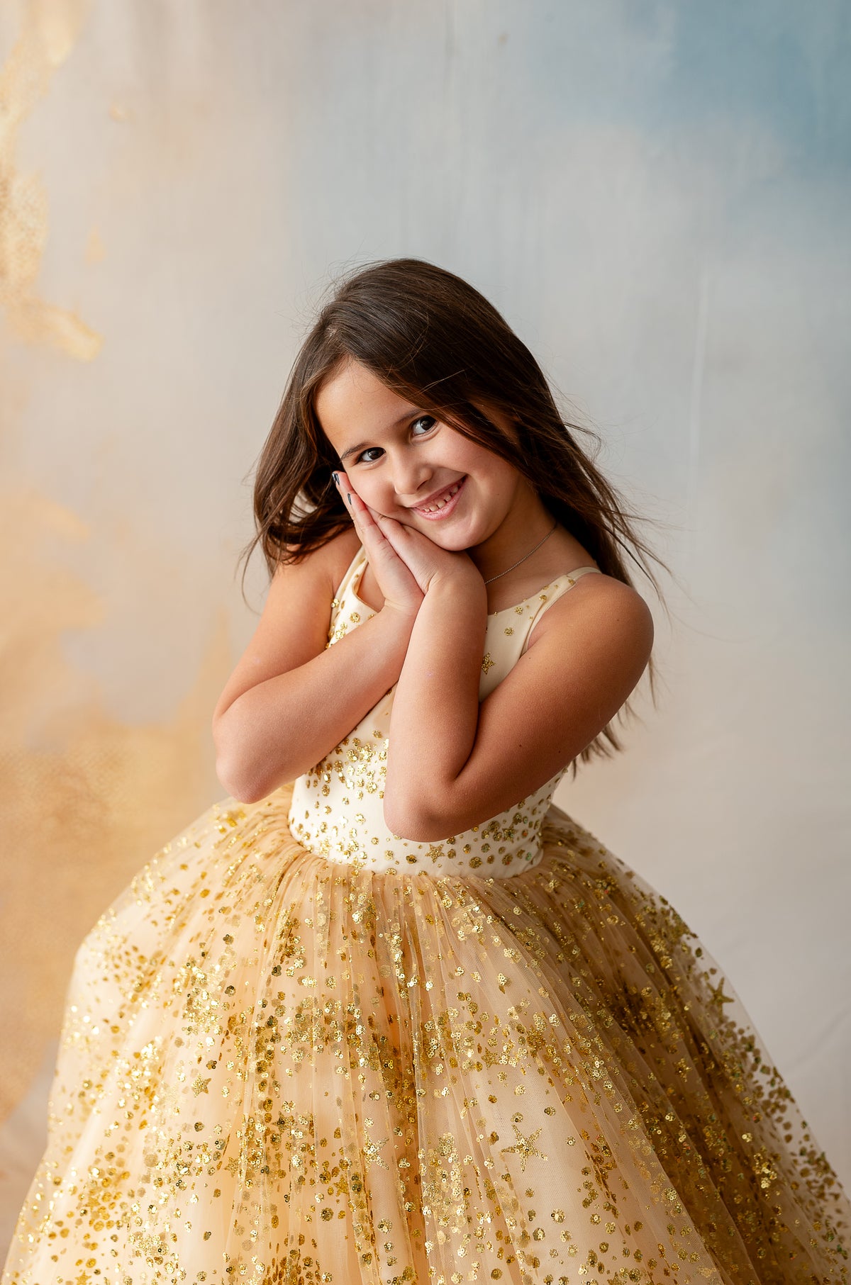 Girl dancing in dreamy gold gown with shimmering details


