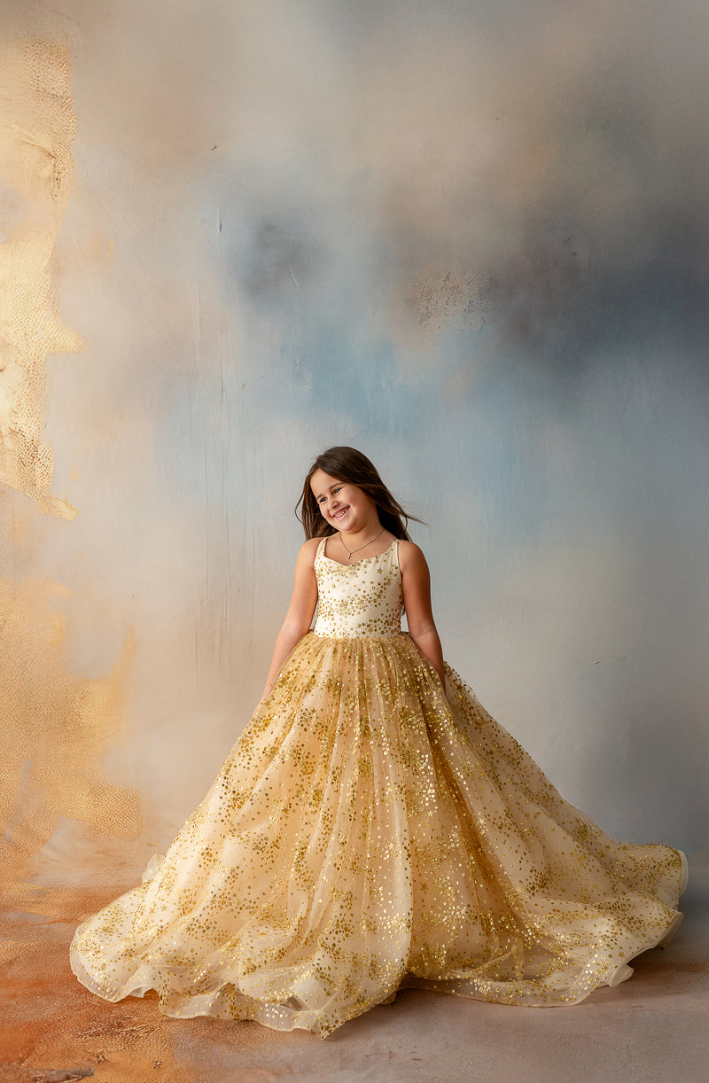 Girl walking away in flowing gold star glitter gown

