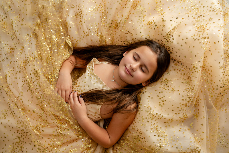 Close-up of girl’s hands holding delicate tulle layers

