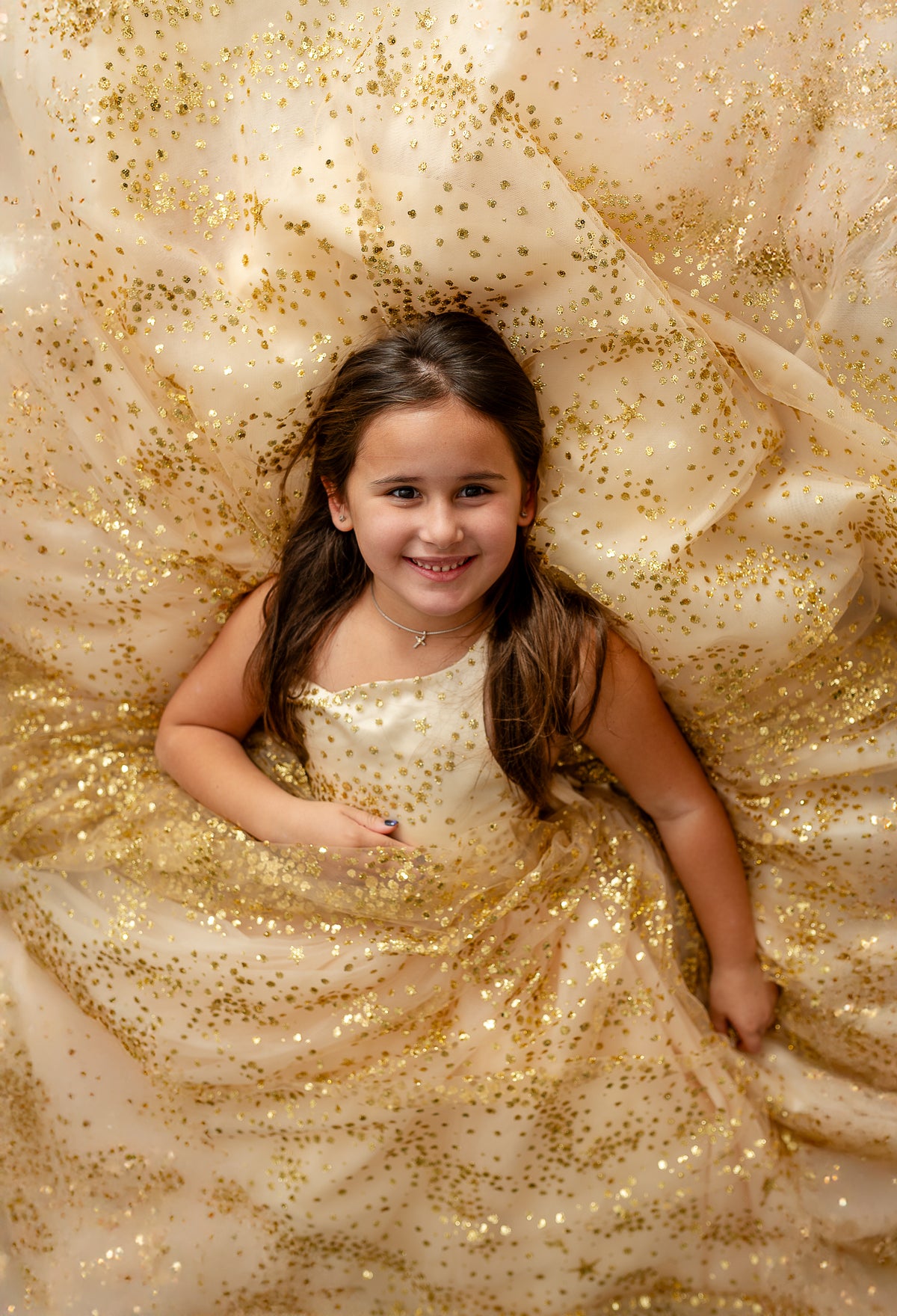 Front view of gold glitter gown with starry detail and bow

