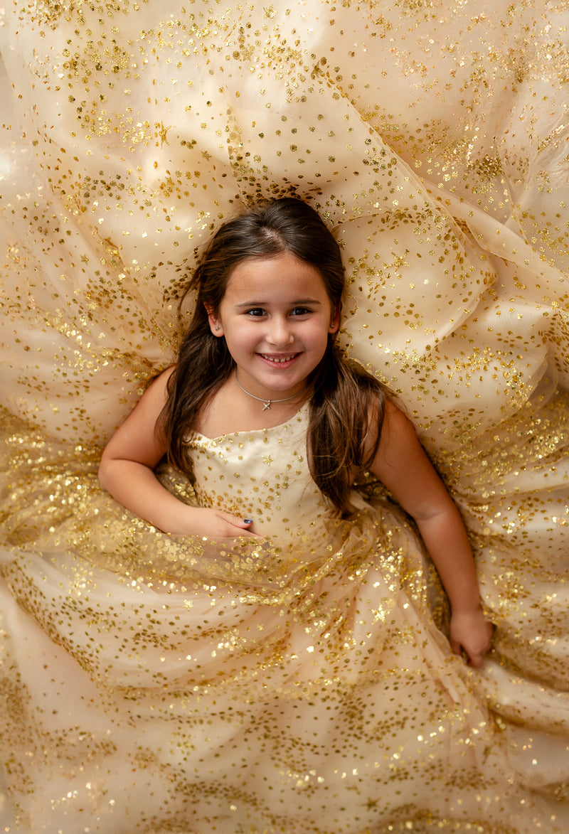 Front view of gold glitter gown with starry detail and bow

