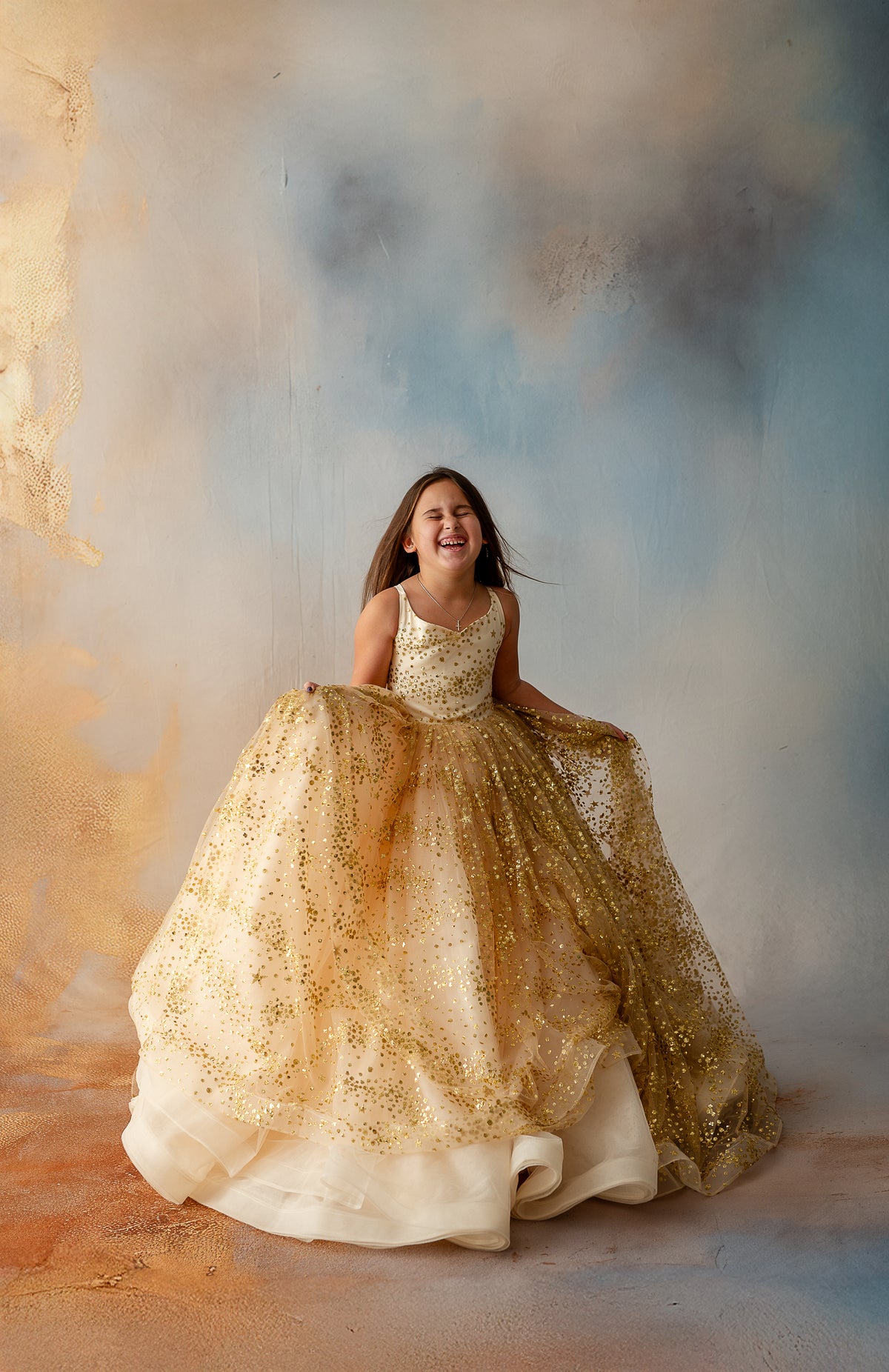 Girl dancing in dreamy gold gown with shimmering details

