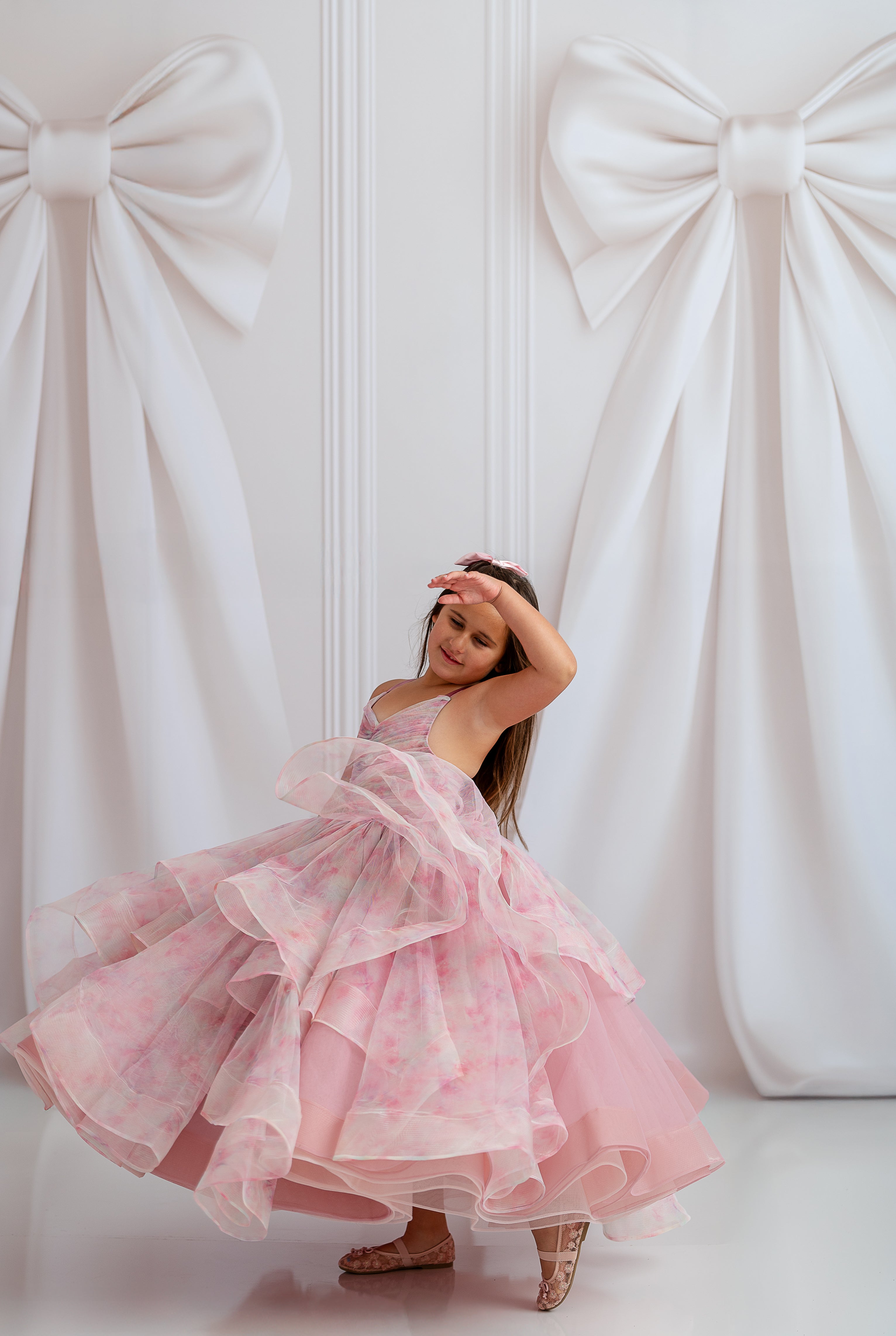 "Child wearing Pastel Clouds Dress, twirling in soft tulle layers under golden light"


