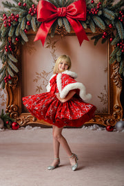 Child wearing red velvet sequin bow dress with matching hooded cape and faux fur trim

