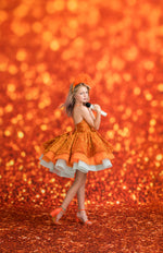 Girl in an orange dress posing against a glittery orange background- Taylor Swift Inspired - LIFE OF A SHOWGIRL
