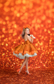 Girl in an orange dress posing against a glittery orange background- Taylor Swift Inspired - LIFE OF A SHOWGIRL
