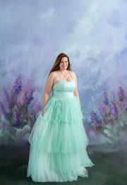 A little girl twirls in her voluminous gown while holding hands with her mother in a matching dress.
