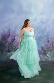 A mother-daughter duo stands together in elegant tulle gowns, creating a whimsical and dreamy portrait.

