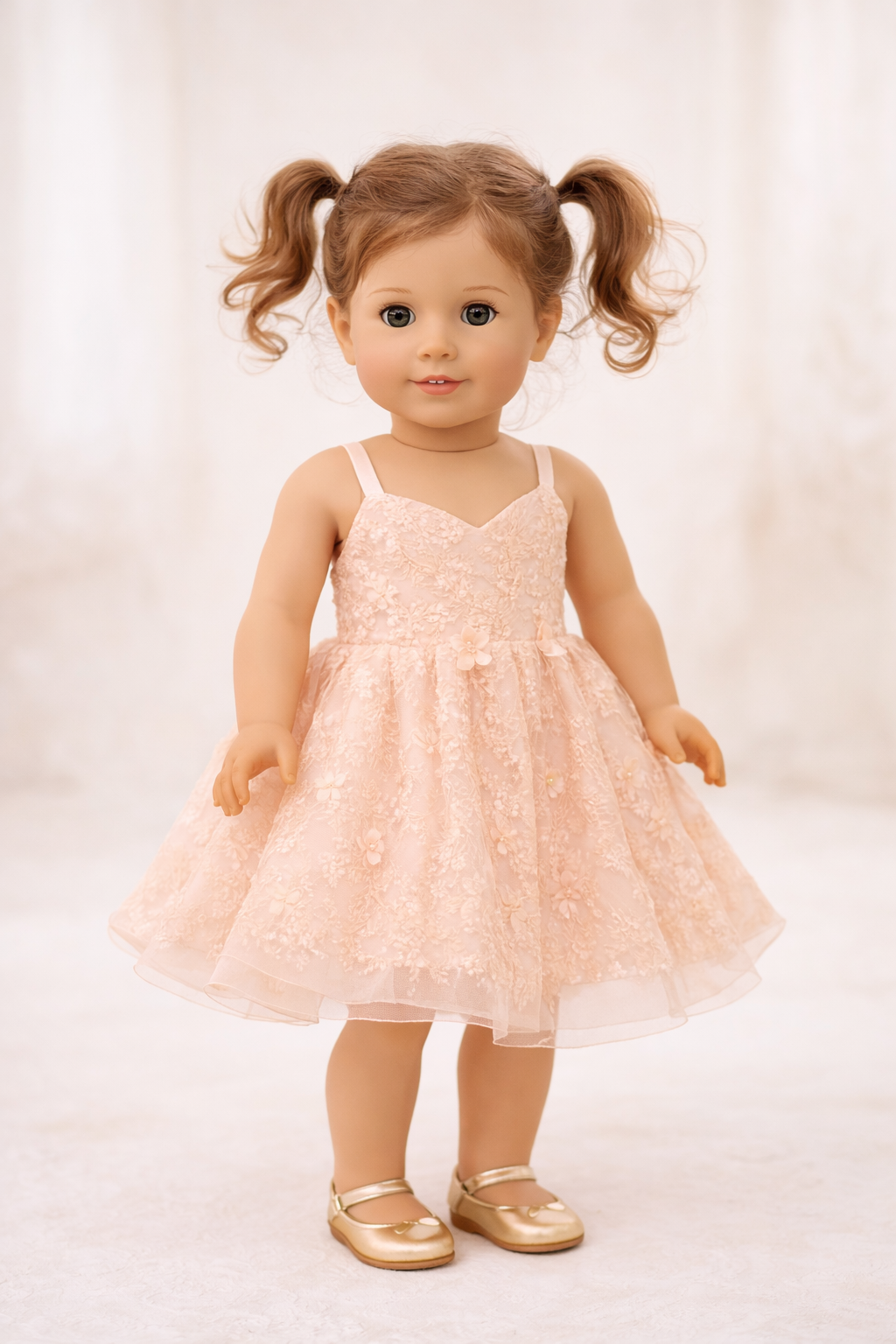 Doll wearing a pink lace dress with pigtails on a white background
