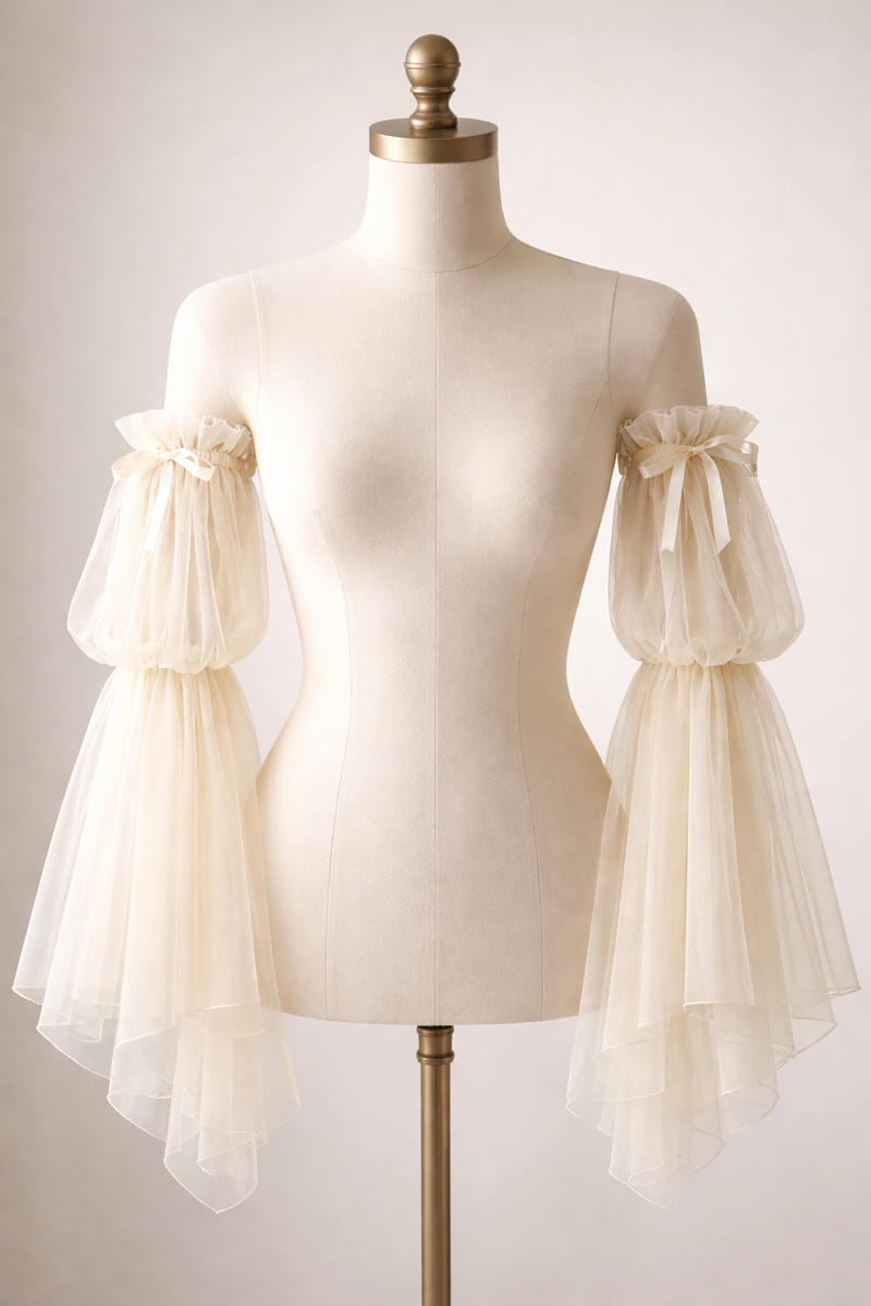 Mannequin wearing a cream-colored dress with sheer sleeves on a plain background