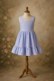 Blue checkered dress on a wooden mannequin against a floral-patterned background